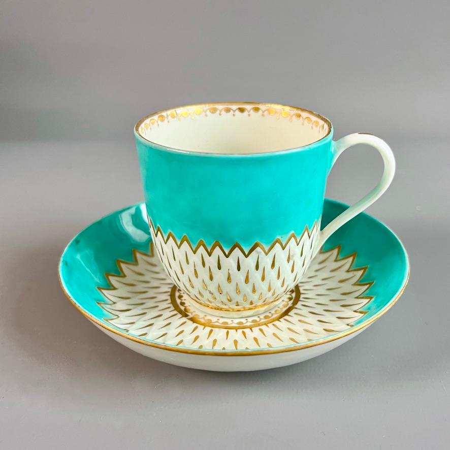 Dies ist eine schöne Kaffeetasse mit Untertasse, die um 1785 in Derby hergestellt wurde. Das Set hat die charakteristische Artischockenleiste und einen leuchtend türkisfarbenen Grund, auf dem die weiße Artischockenoberfläche vergoldet ist. Dieses