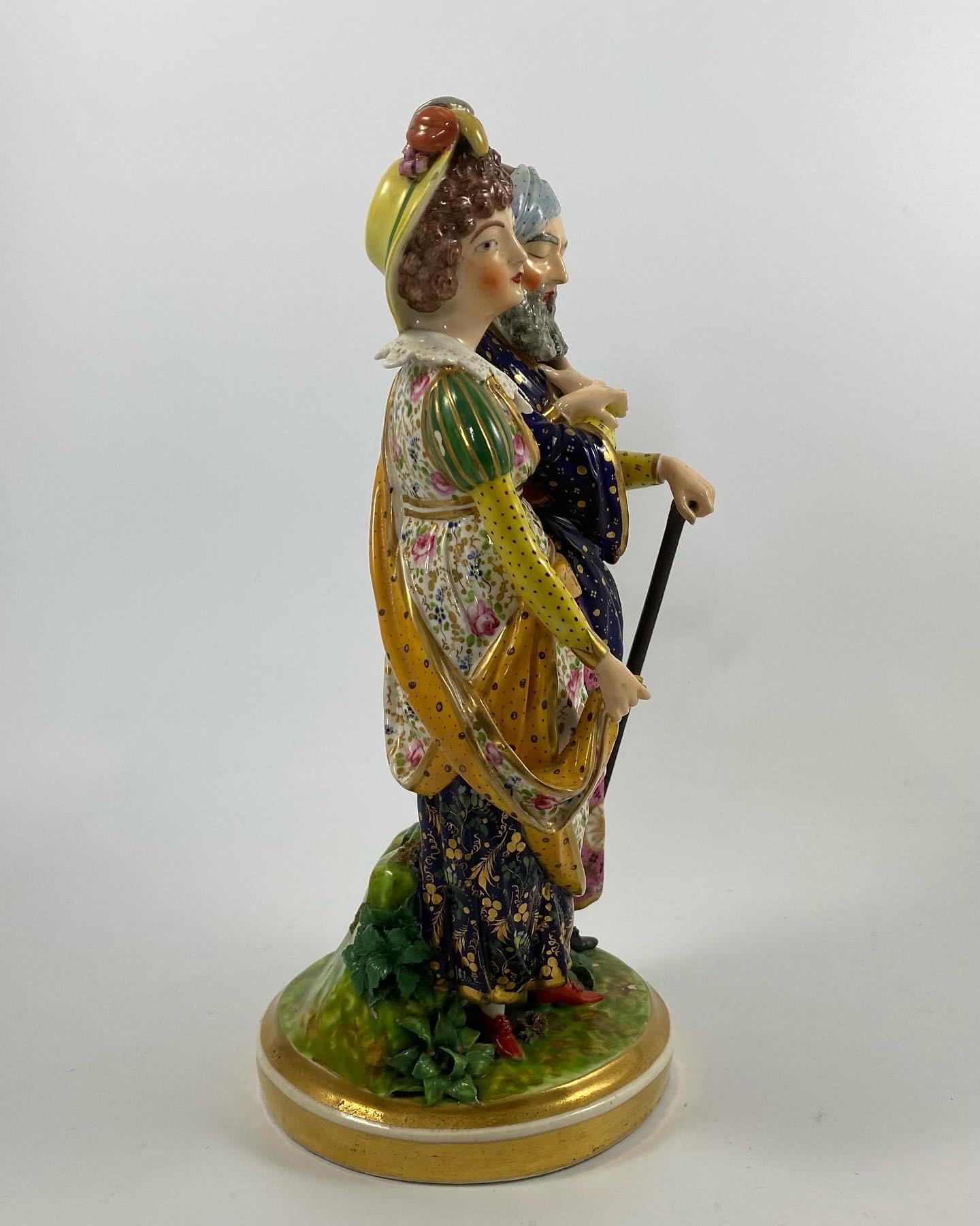 A rare Derby porcelain figure of Belisarius and his daughter, c. 1820. Probably modelled by J.J. Spangler, as a young woman, wearing 18th Century costume, supporting her elderly, blind father, who wears Classical attire, and a turban. They stand