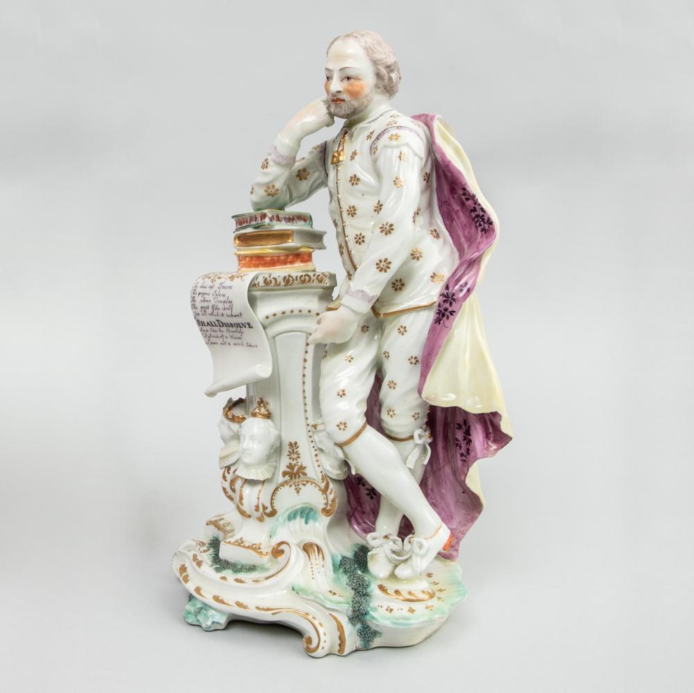 Derby porcelain figure of shakespeare,
circa 1765.

The patch mark period figure depicts Shakespeare standing with his right elbow resting on a pile of books with an open scroll which all rest upon a column with crowned heads at each corner and a