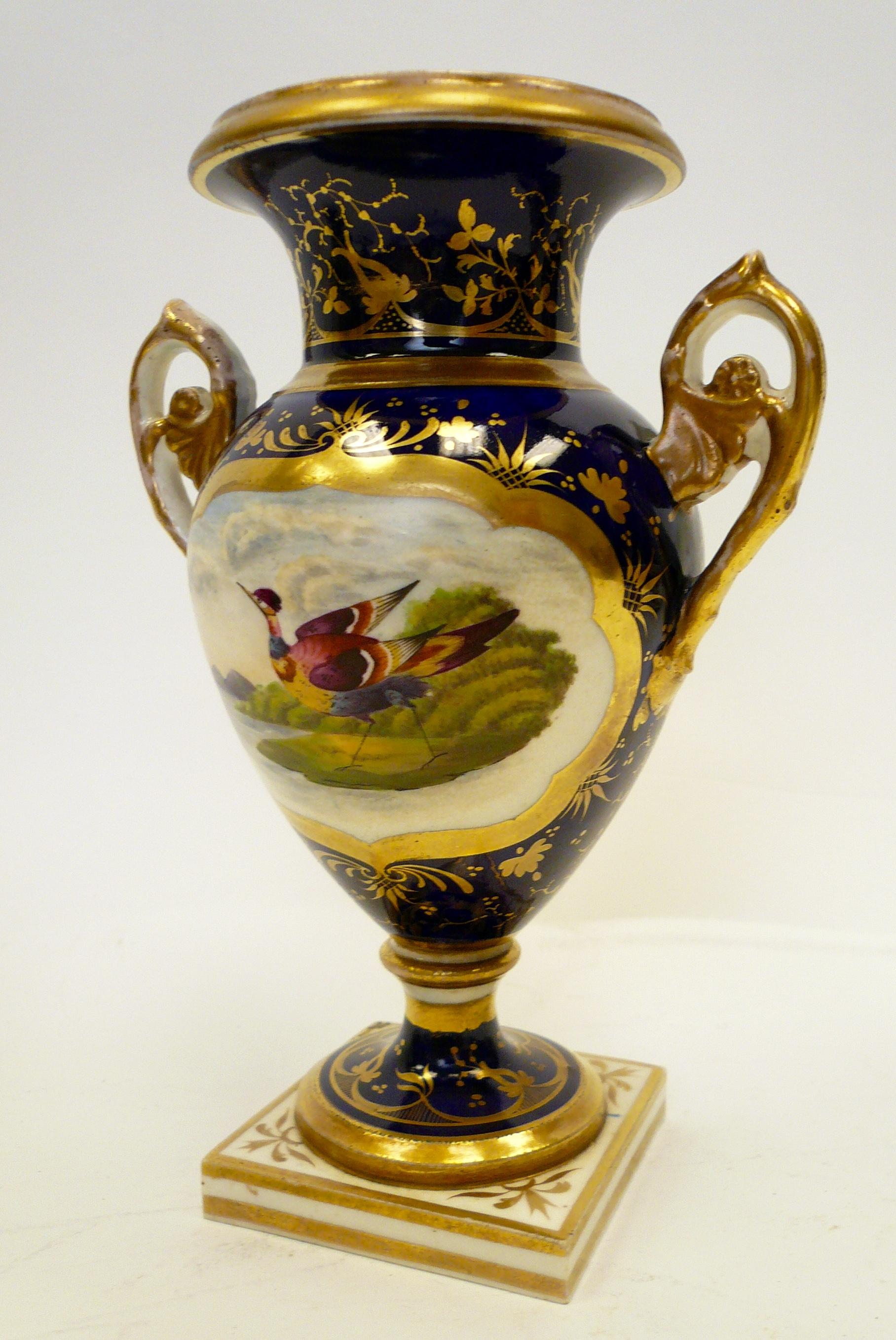 Diese wunderschön handbemalte Urne aus Derby-Porzellan zeigt einen exotischen Vogel in einer Landschaft und vergoldete Verzierungen auf einem kobaltfarbenen Grund.