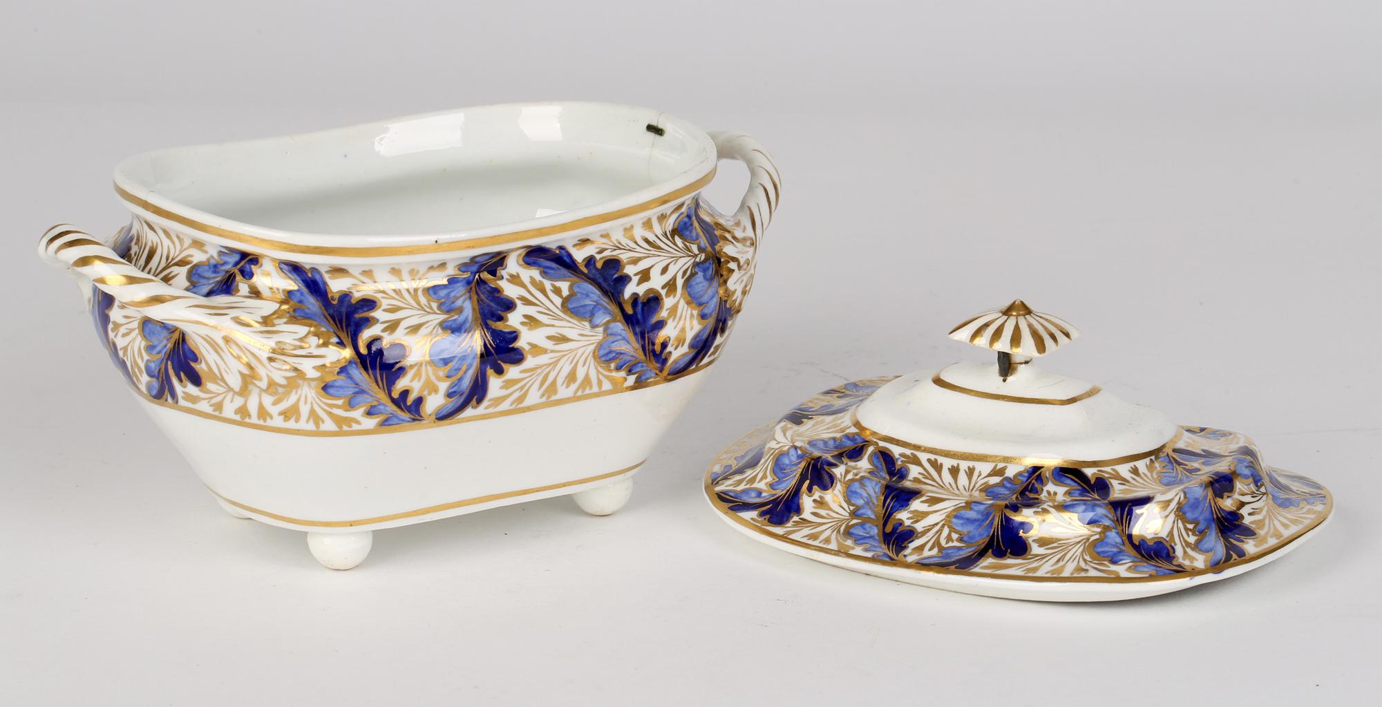 A stylish English Georgian porcelain lidded twin handled sucrier and stand decorated in a leaf pattern by Derby Porcelain Works and dating from around 1820. The rounded shaped rectangular form sucrier stands raised on four ball shaped feet with