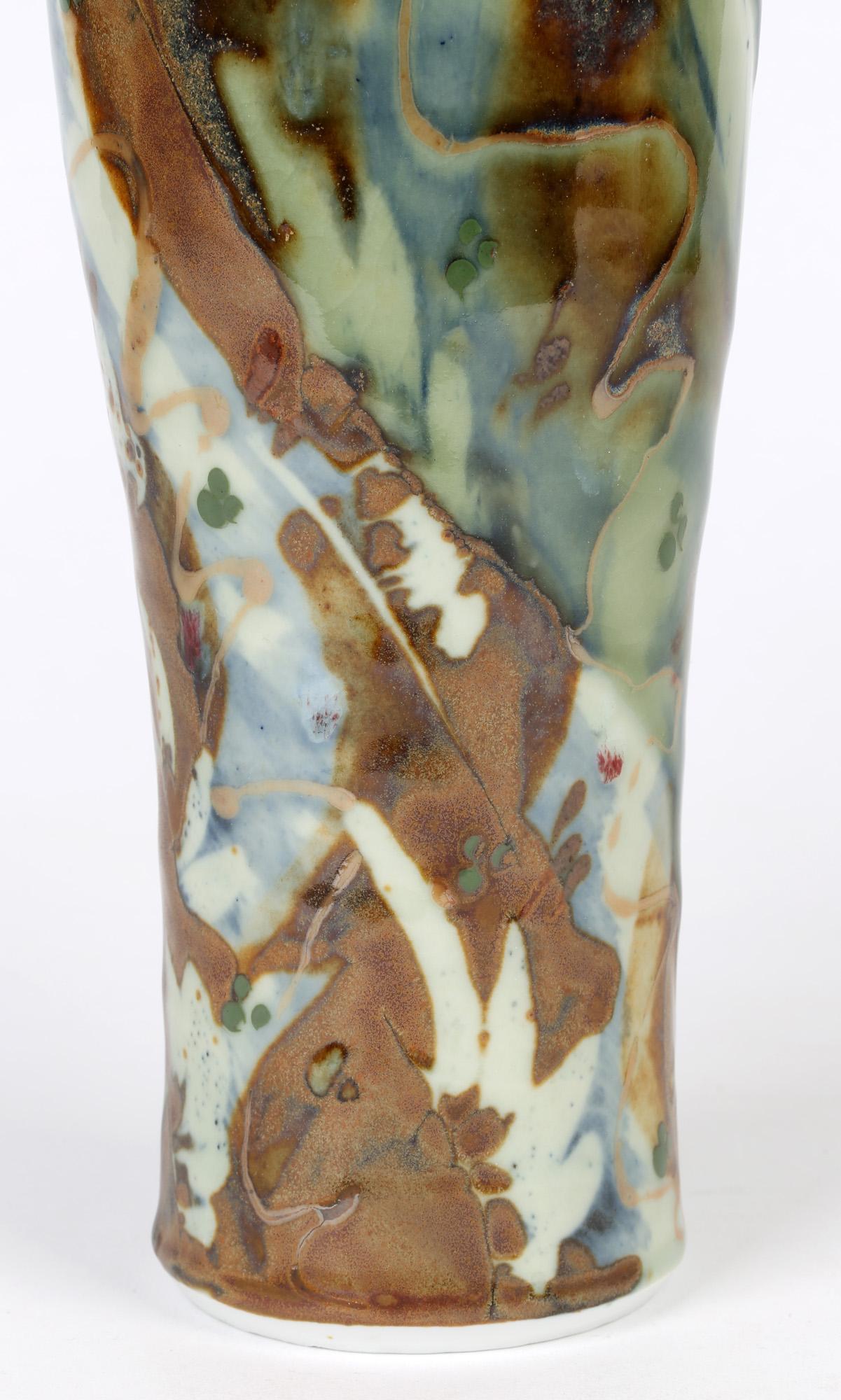 A tall and striking studio pottery porcelain vase decorated in abstract colored glazes on a celadon ground attributed to Derek Clarkson and dating from the 20th century. The vase formed part of a Derek Clarkson collection of studio pottery recently