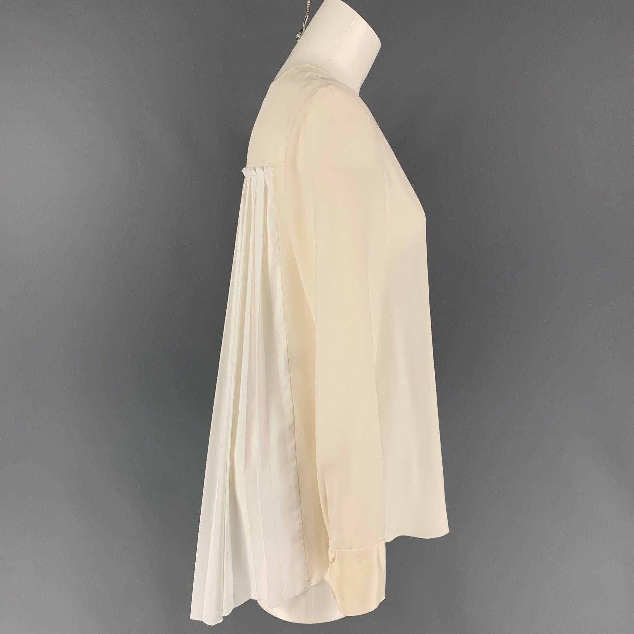DEREK LAM long sleeve blouse comes in a cream & white silk collarless, pleated back, and a hidden placket closure.
Good
Pre-Owned Condition. Discoloration at sleeve cuff. 

Marked:   40 

Measurements: 
 
Shoulder: 15.5 inches  Bust: 38 inches 
