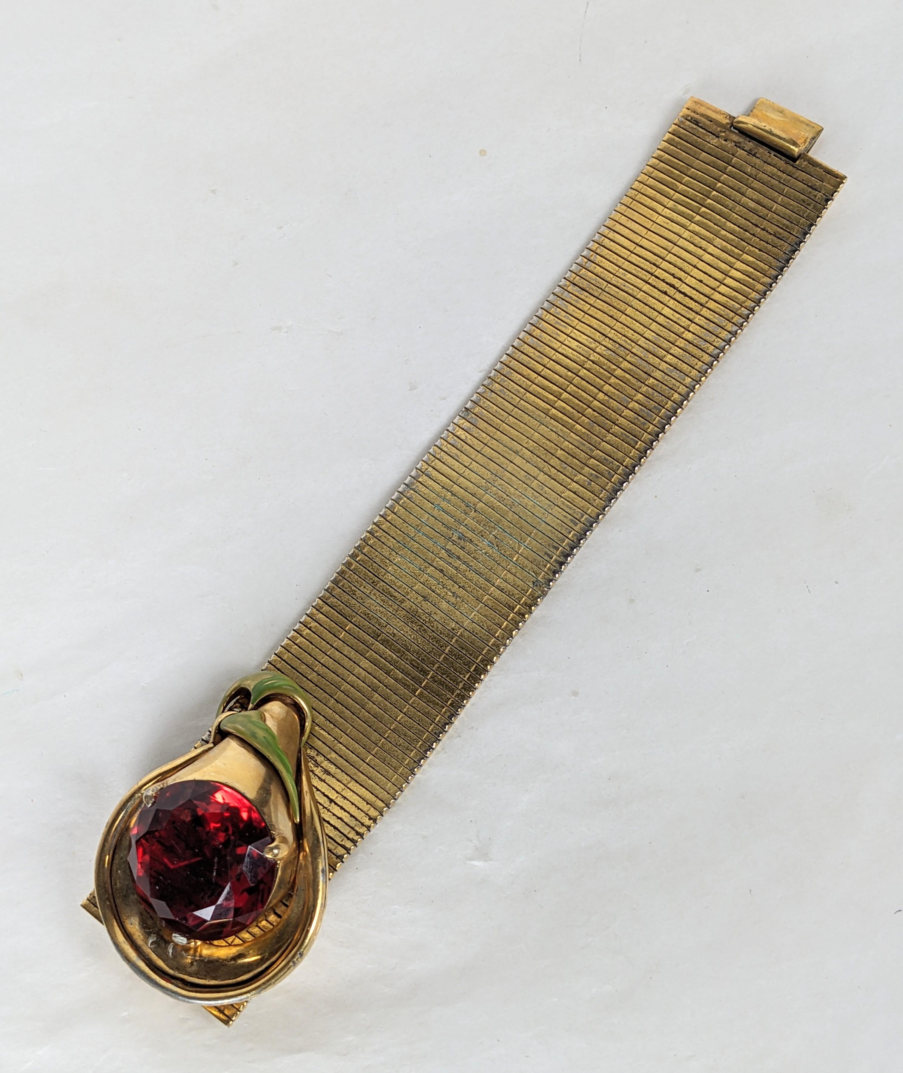 Pulsera brazalete acanalada flexible DeRosa Retro Calla Lilly de  Base metálica chapada en oro con una gran piedra facetada redonda de imitación de topacio coñac. El engaste escultórico chapado en oro es la firma DeRosa con esmalte verde en frío.