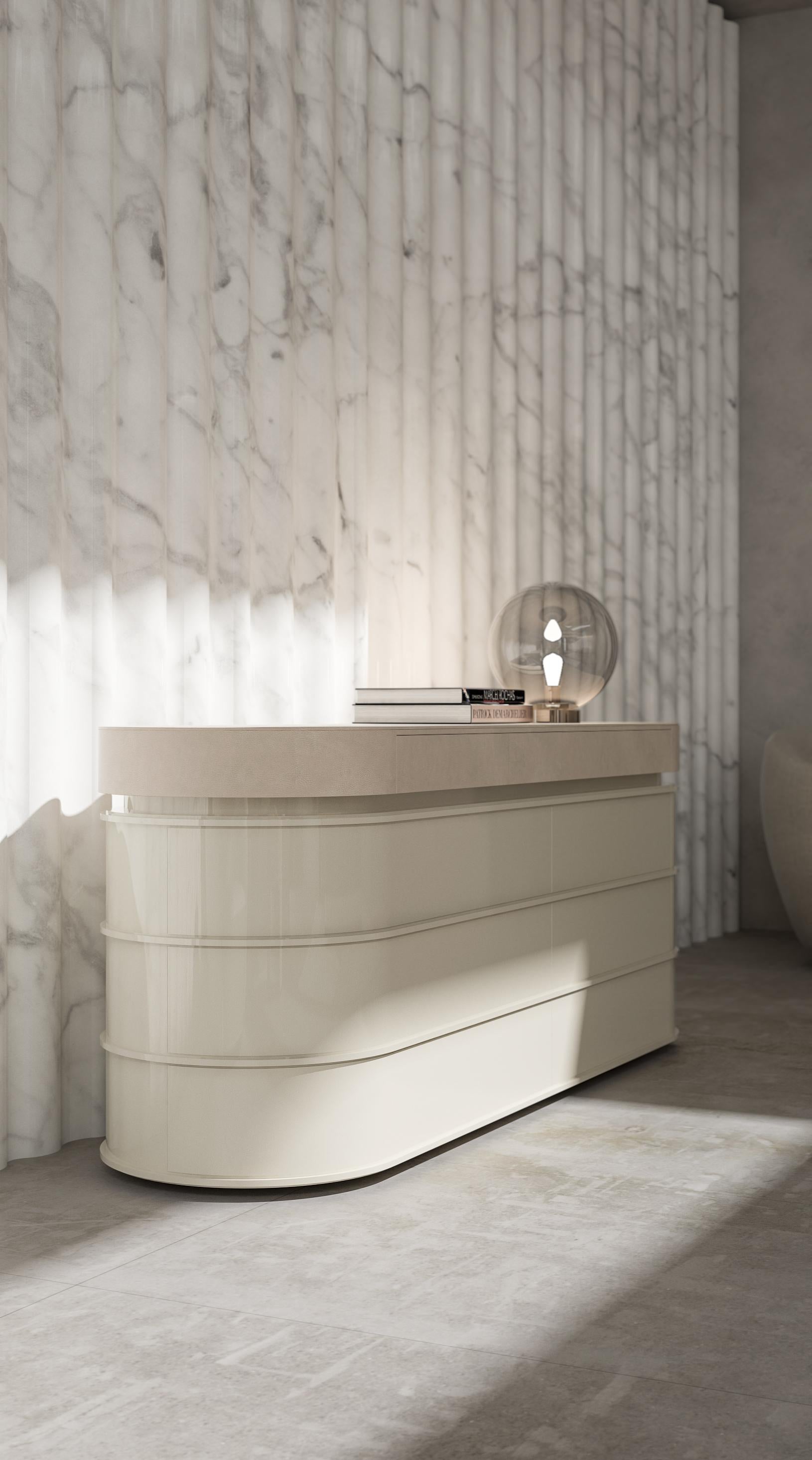 This dresser features a rounded design with a lacquered structure and a leather top, combining elegance and sophistication. The smooth lacquered finish enhances its modern appeal, while the leather top adds a touch of luxury and refinement. Its