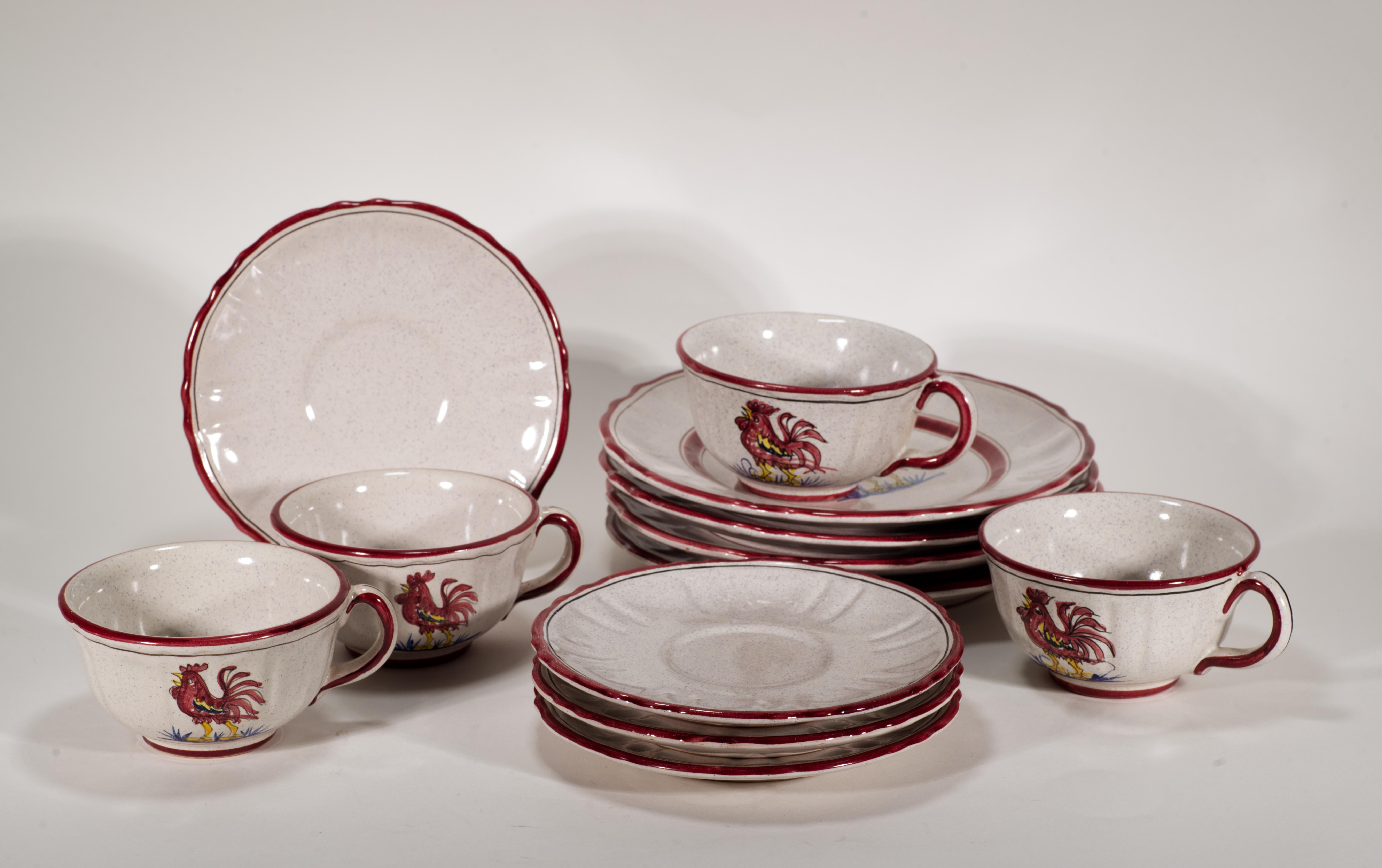  El juego vintage de tazas, platillos y platos, con un total de 4 ajustes, se fabricó en la región italiana de Deruta para Aldea Campesina. Está pintada a mano con un motivo de Gallo rojo sobre fondo gris claro moteado con llantas dobles rojas y