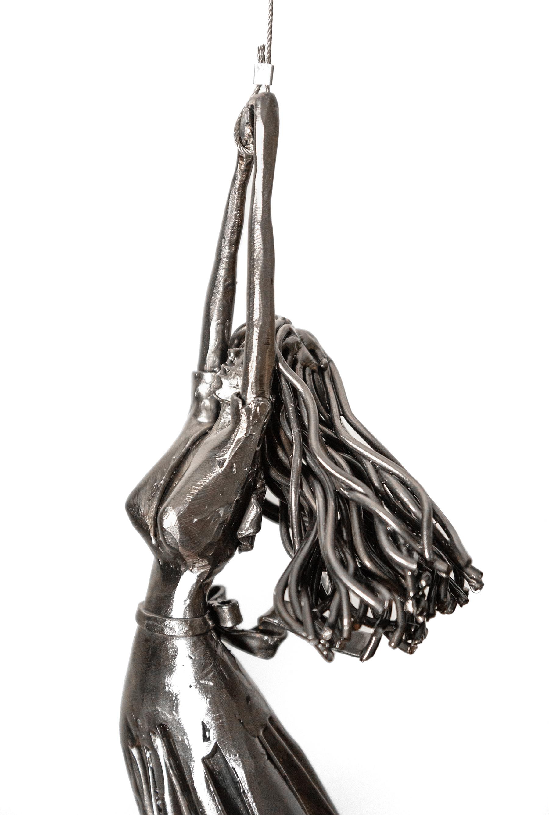 Derya Ozparlak’s provocative sculptures wrestle with ideas about escape, belonging and freedom. In this new piece, a young woman appears to be hanging on to a balloon for dear life. Forged from steel and highly polished, the woman is wearing a short