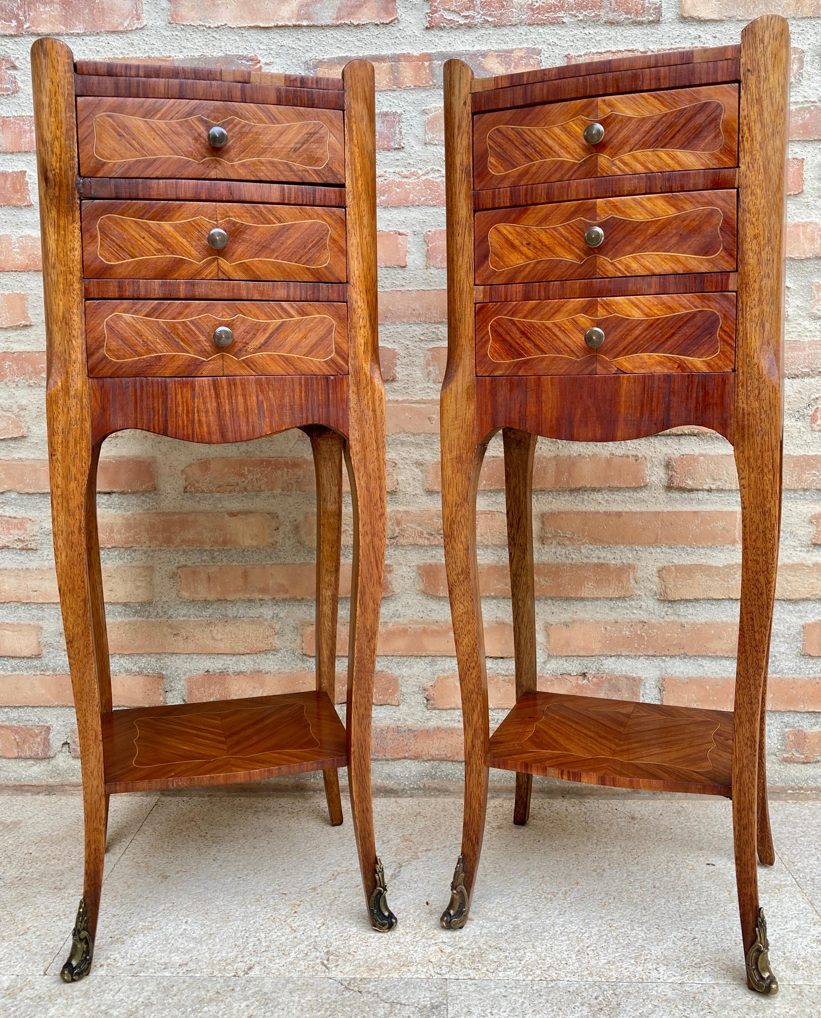 Pair of French walnut bedside tables adorned with fine Louis XV marquetry from the early 19th century. This pair of French 'tables de chevet' was created in the early years of the 19th century, at a time when the country revisited the rococo style