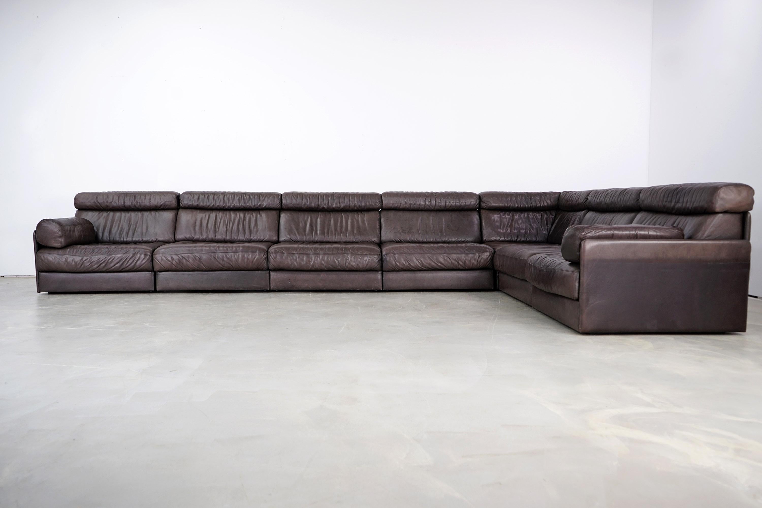 High-quality sofa from Swiss quality manufacturer DeSede. This corner sofa consists of seven seating elements, each of which can be folded out into a sleeping unit. The thick, soft leather is in very good condition with no cracks or holes and shows