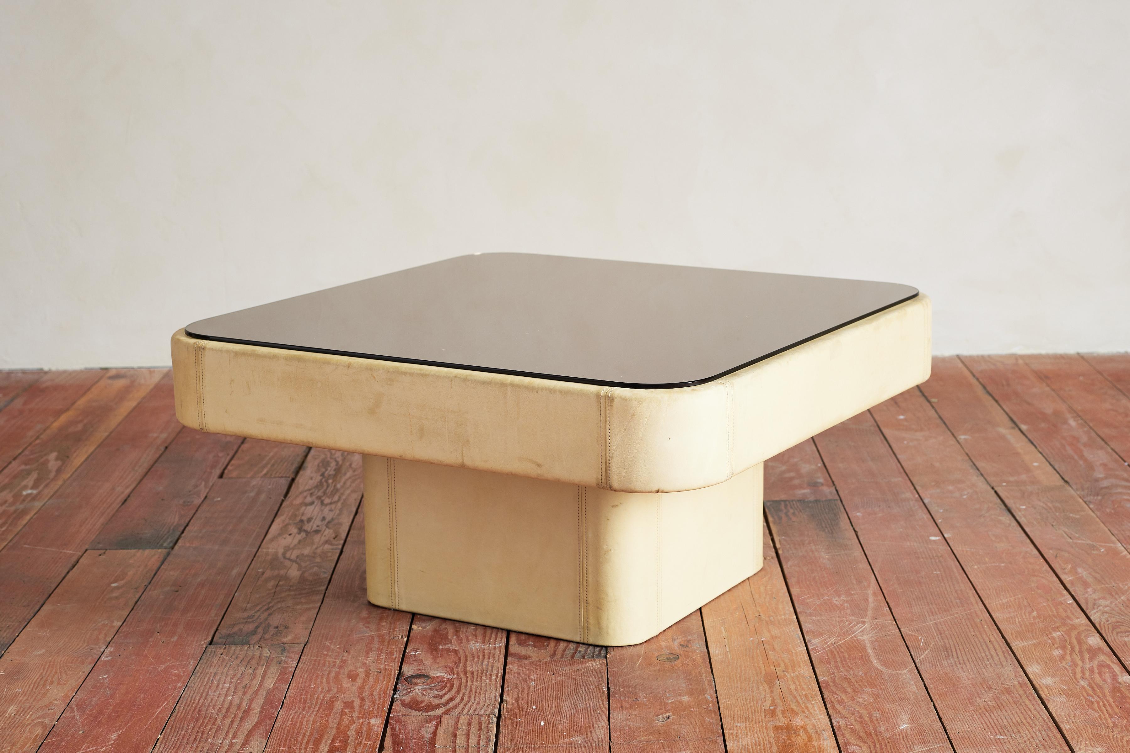 De Sede coffee table in creamy white leather and smoky glass top. 

Signature patchwork leather base with wonderful patina.

Switzerland, 1950s.