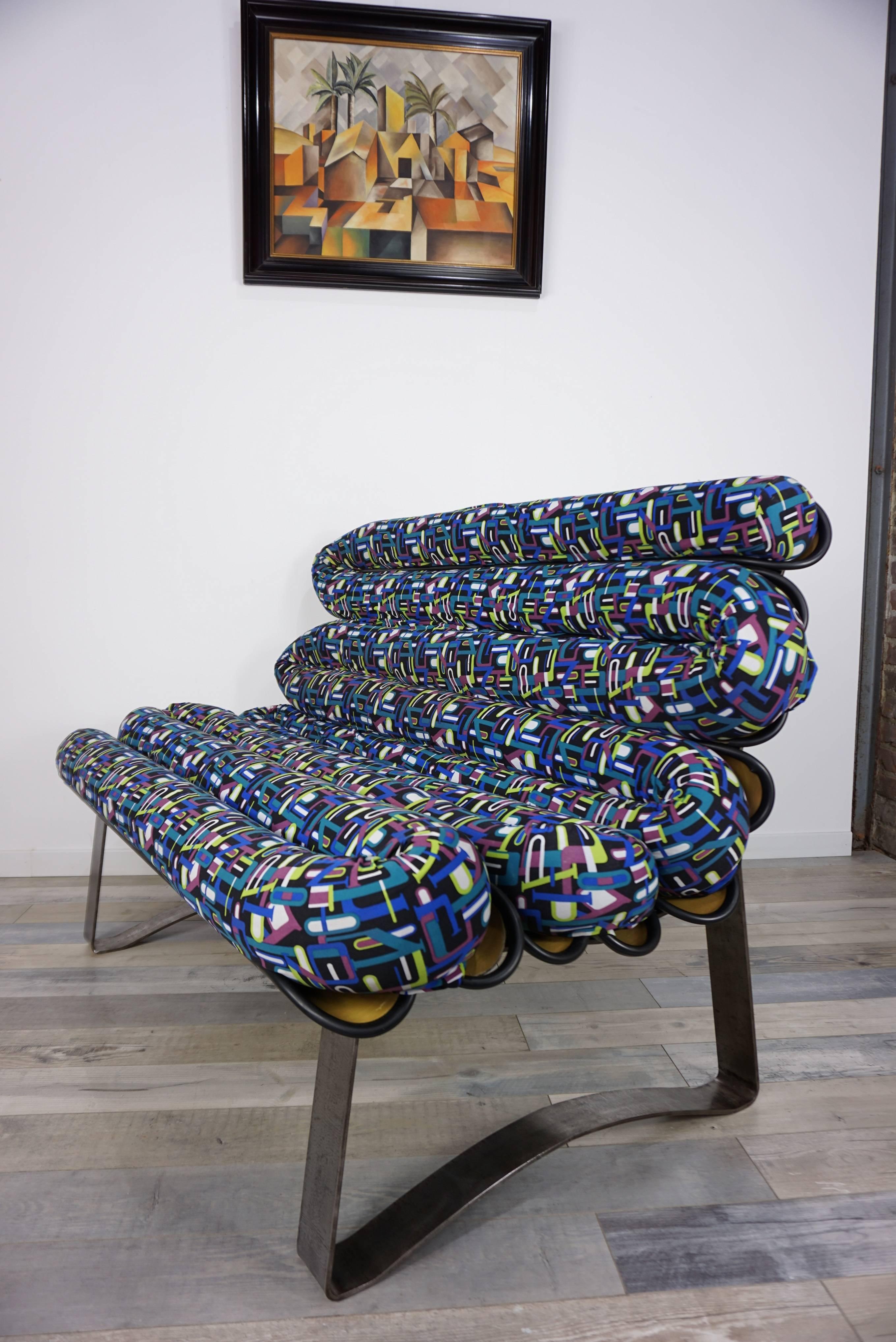 Canapé design et tissu coloré (coussin d'assise et housse de tissu amovibles) avec coque en fibre de verre et pieds luge en métal brossé.