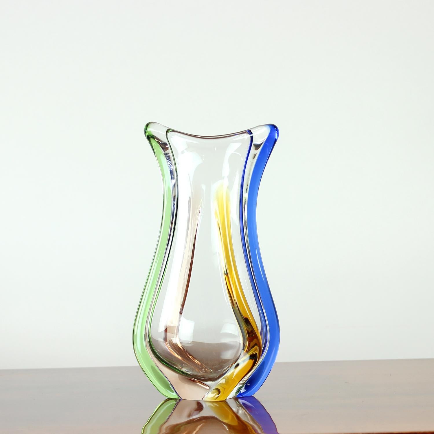 A beautiful example of Czech mid-century glass, this handblown vase was designed by František Zemek in the 1960s for the famed Škrdlovice glassworks. Part of the Rhapsody collection, it features a clear base with vibrant rainbow-like stripes that