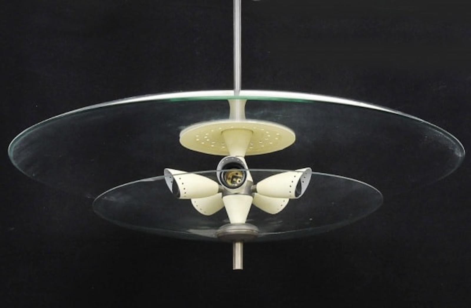 Design brasiliano. Ciondolo futuristico, 1960 ca.
Metallo e vetro
75 x 75 x 70 cm
La sospensione ha cinque bruciatori con struttura in metallo cromato e due vassoi convessi in vetro traslucido.