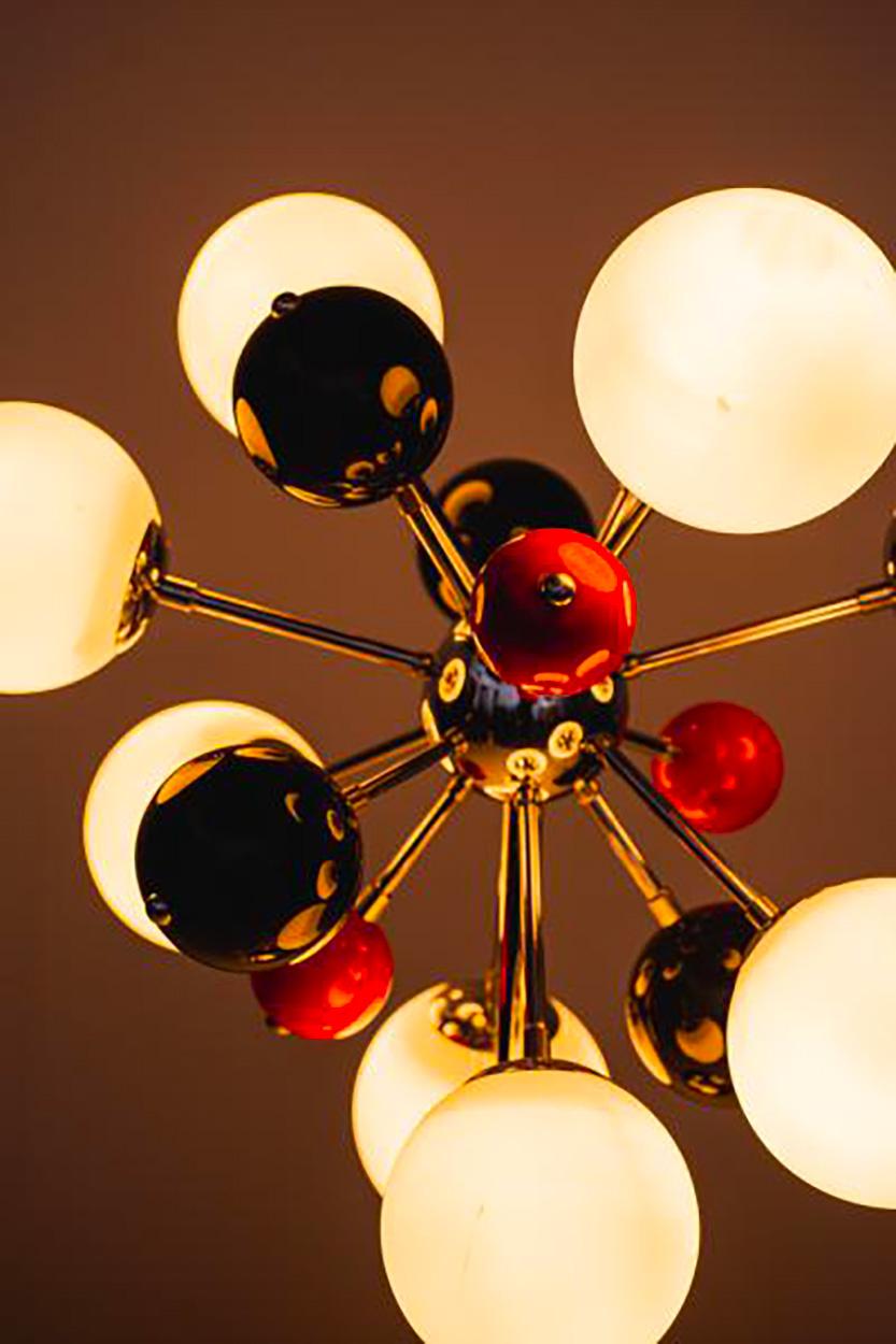 Design brésilien, circa 1970.
Rare lampe de table dite Sputnik exécutée en métal chromé, sphères rouges et noires et dômes sphériques en verre blanc.
Très bon état. 
Le système d'électricité à été changé en accord aux normes européennes.
 