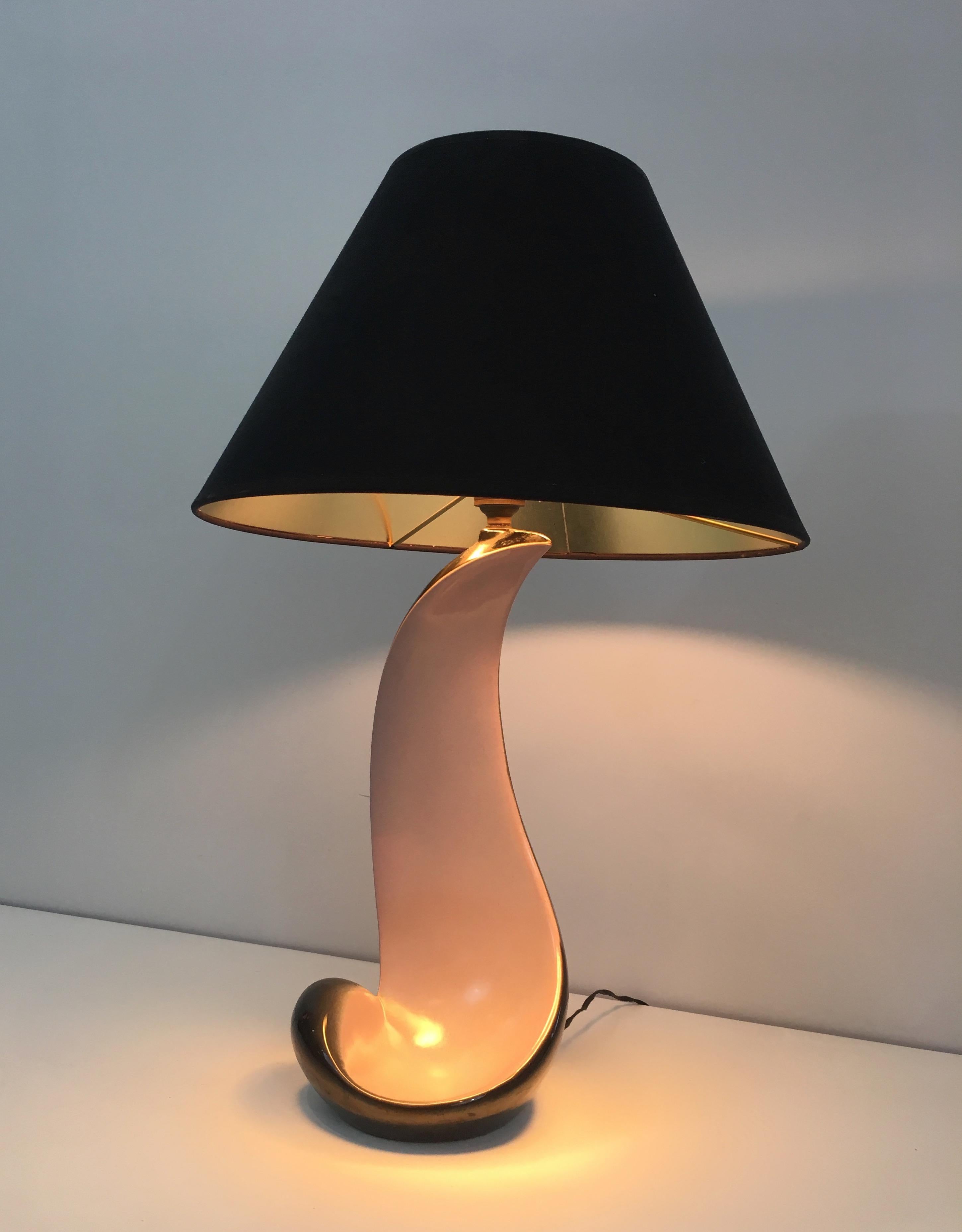 This design lamp is made of a glazed white and black ceramic. This table lamp has a new black shintz shade gilt inside. This is a French work, circa 1950.