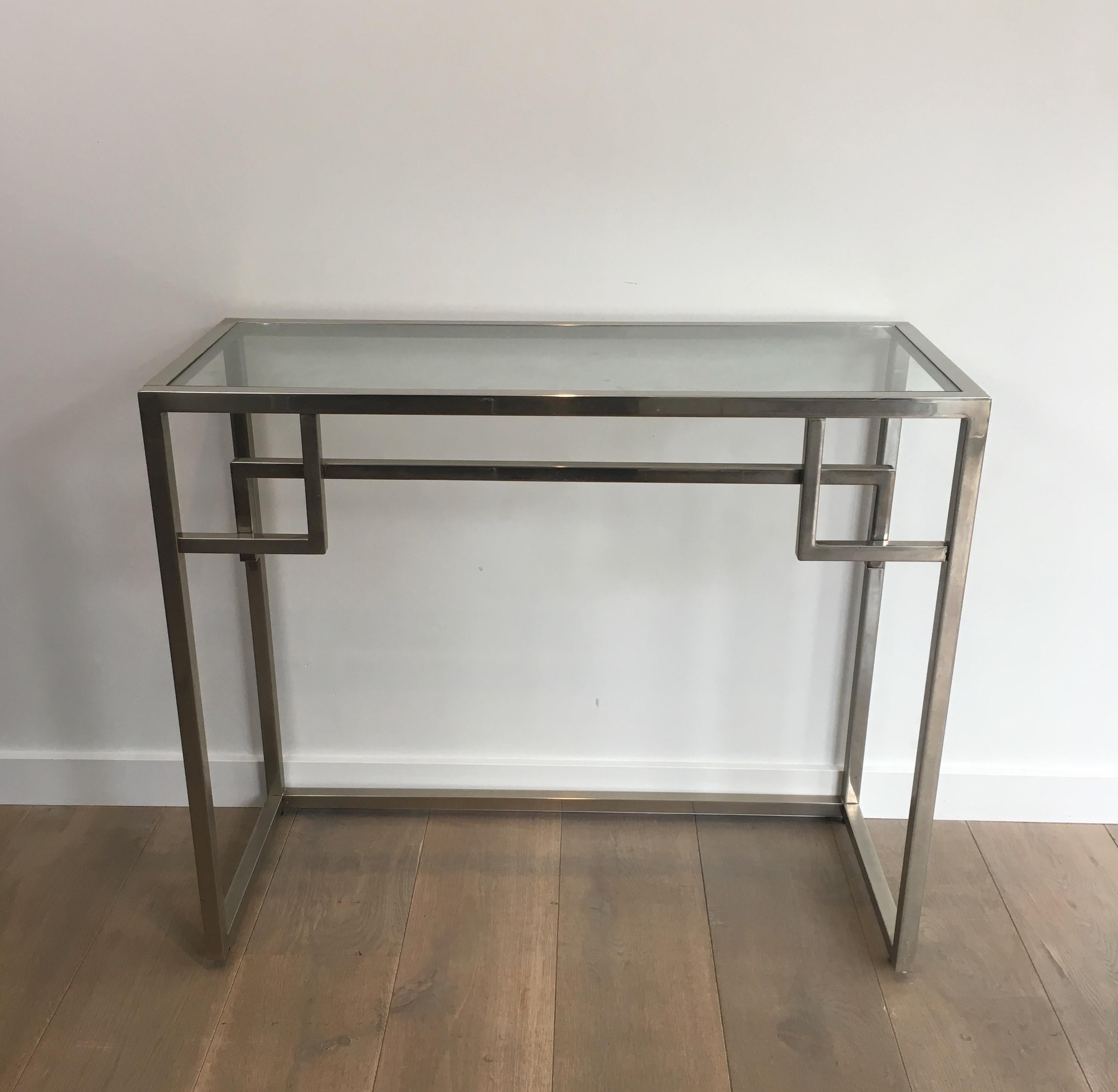 This console table is made of chrome with a clear glass shelf. This is a nice design, very simple and pure. This is a French work, circa 1970.