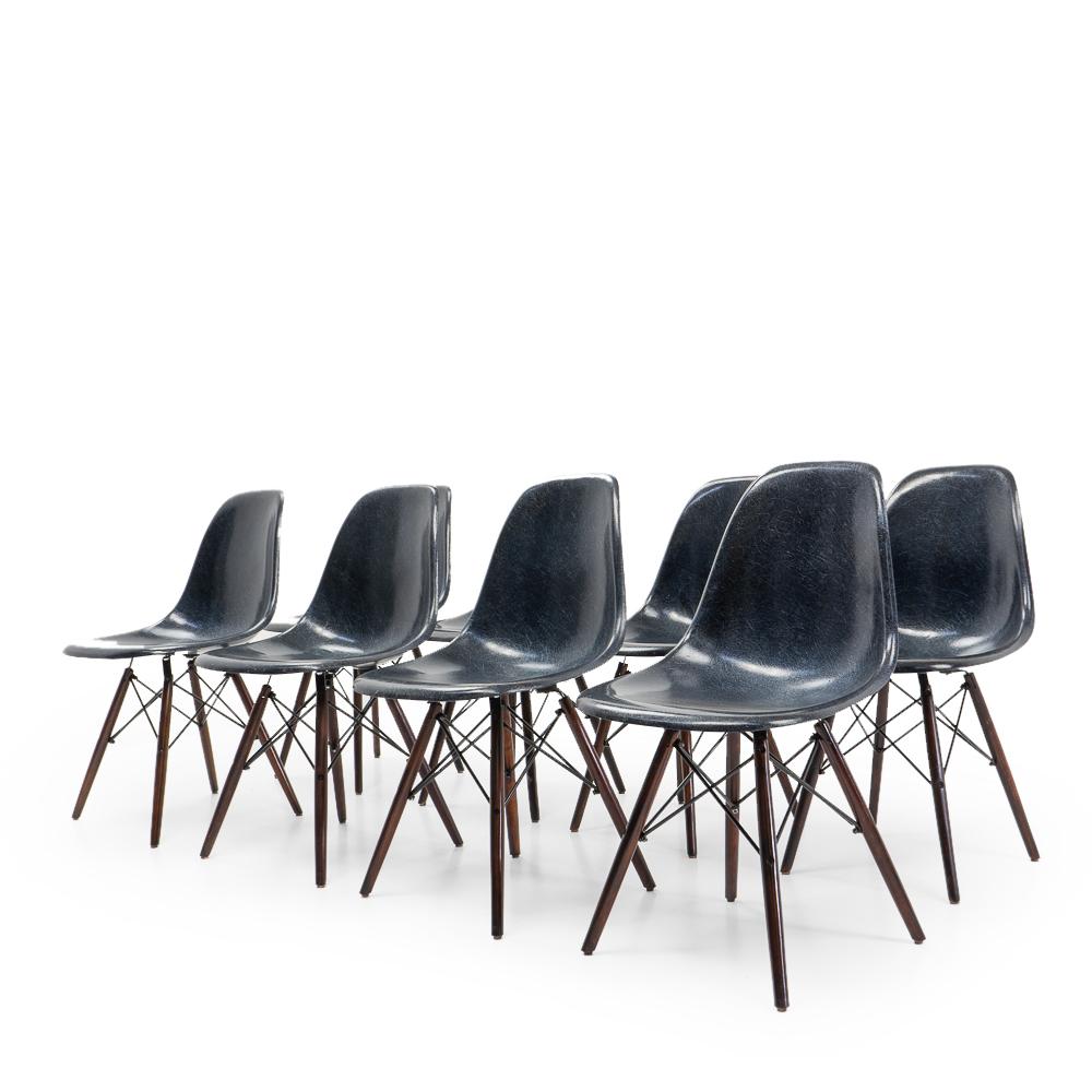 Set of eight dark blue DSW chairs with aftermarket wood dowel base. Designed by Charles & Ray Eames, and produced by Vitra/Herman Miller.

These iconic chairs are in very good condition considering their age, and some very light wear on the shell.
