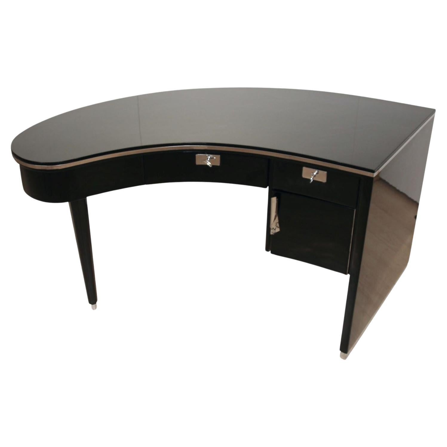 Extraordinary curved (kidney-shaped) designer desk from the 1950/60s.

Asymmetrical shape similar to that of a grand piano. Walnut, high-gloss black finish with piano lacquer. Octagonal tapered feet with metal tips. Circumferential metal trim around