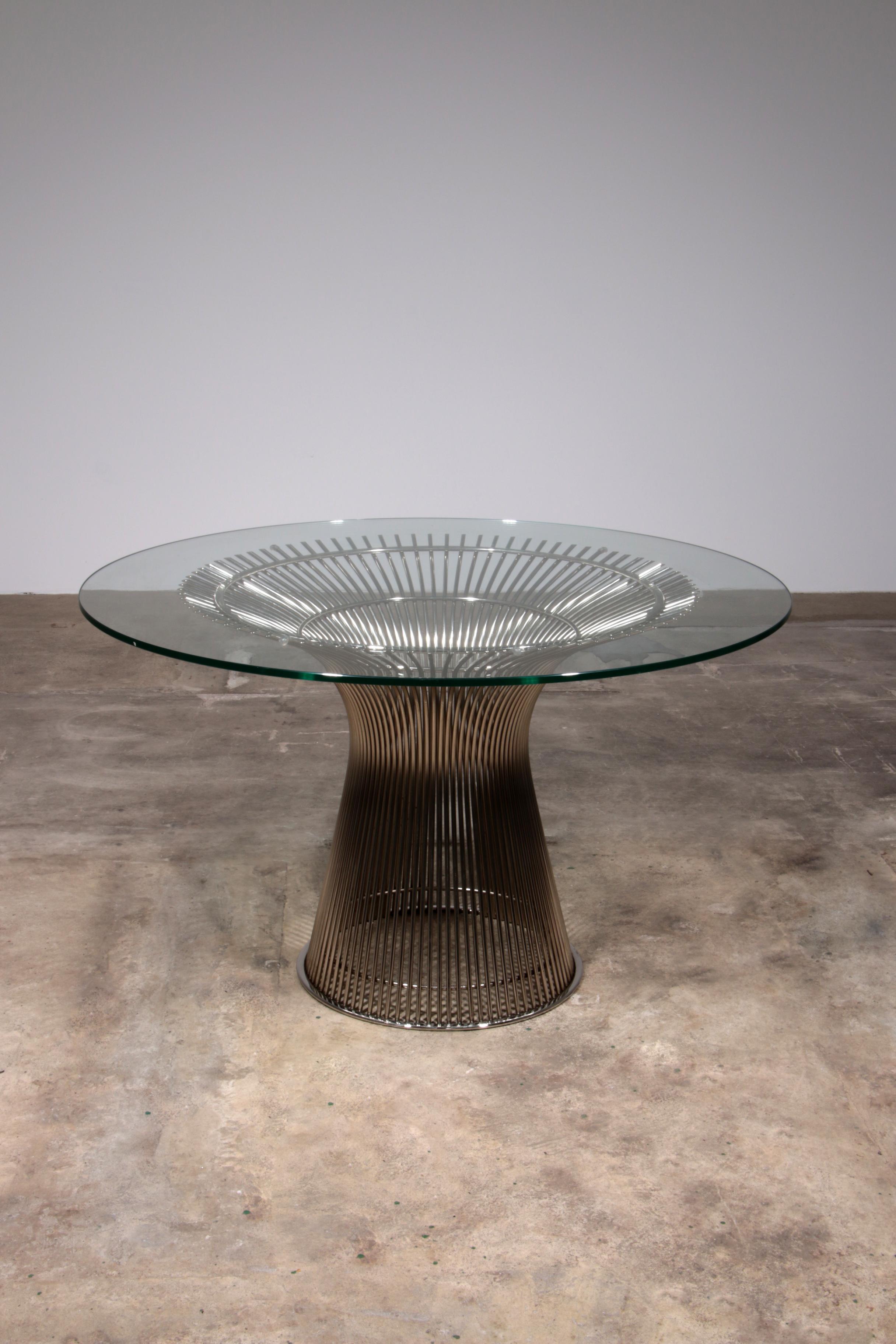 The Platner dining table, designed by renowned American architect and designer Warren Platner for Knoll, is a true icon of modern furniture design. Its distinctive base is crafted from a filigree frame of interwoven steel rods, creating an elegant,