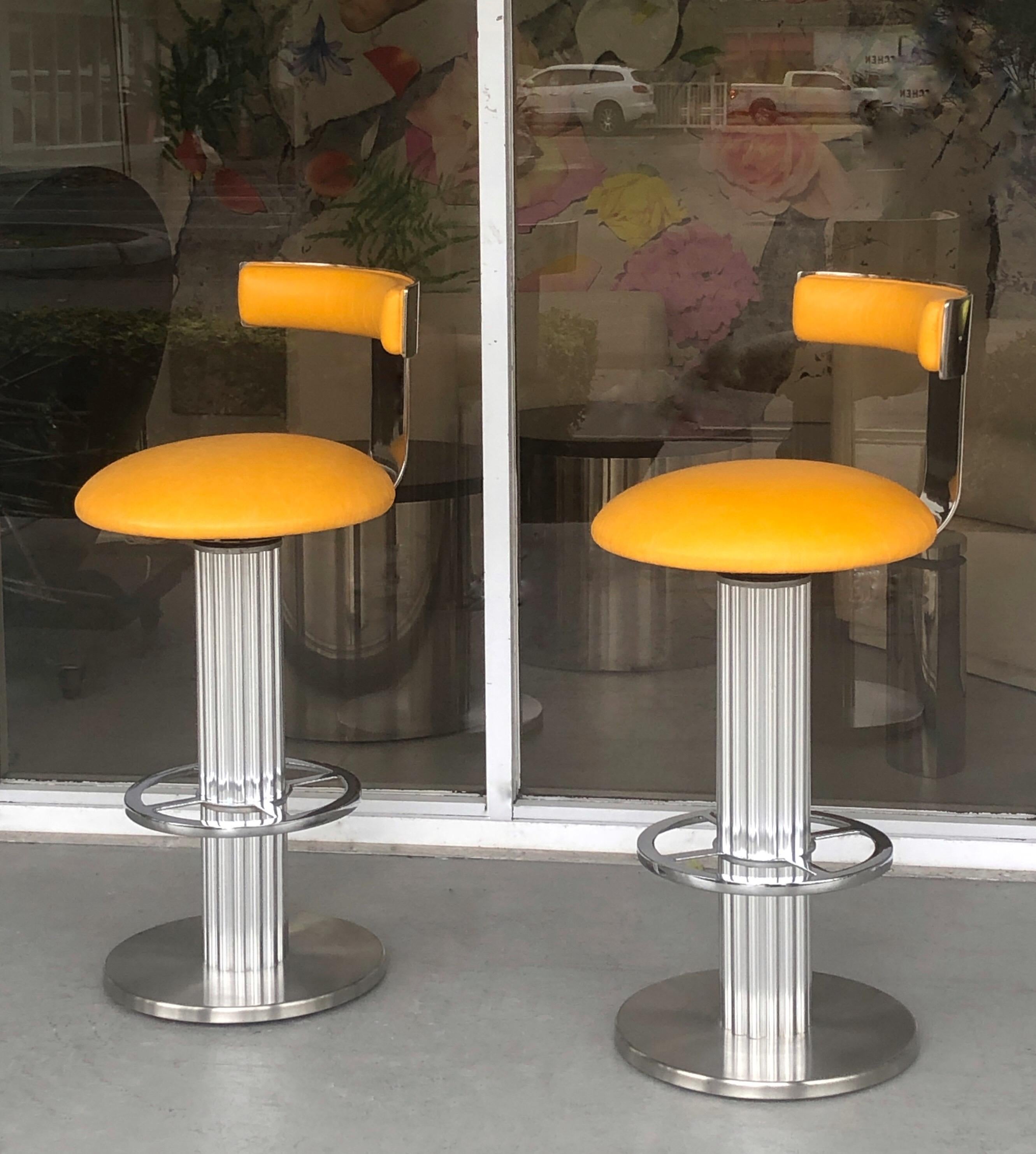A pair of high end bar stools by Designed for a Leisure. Yellow leather upholstery. Seat swivel.