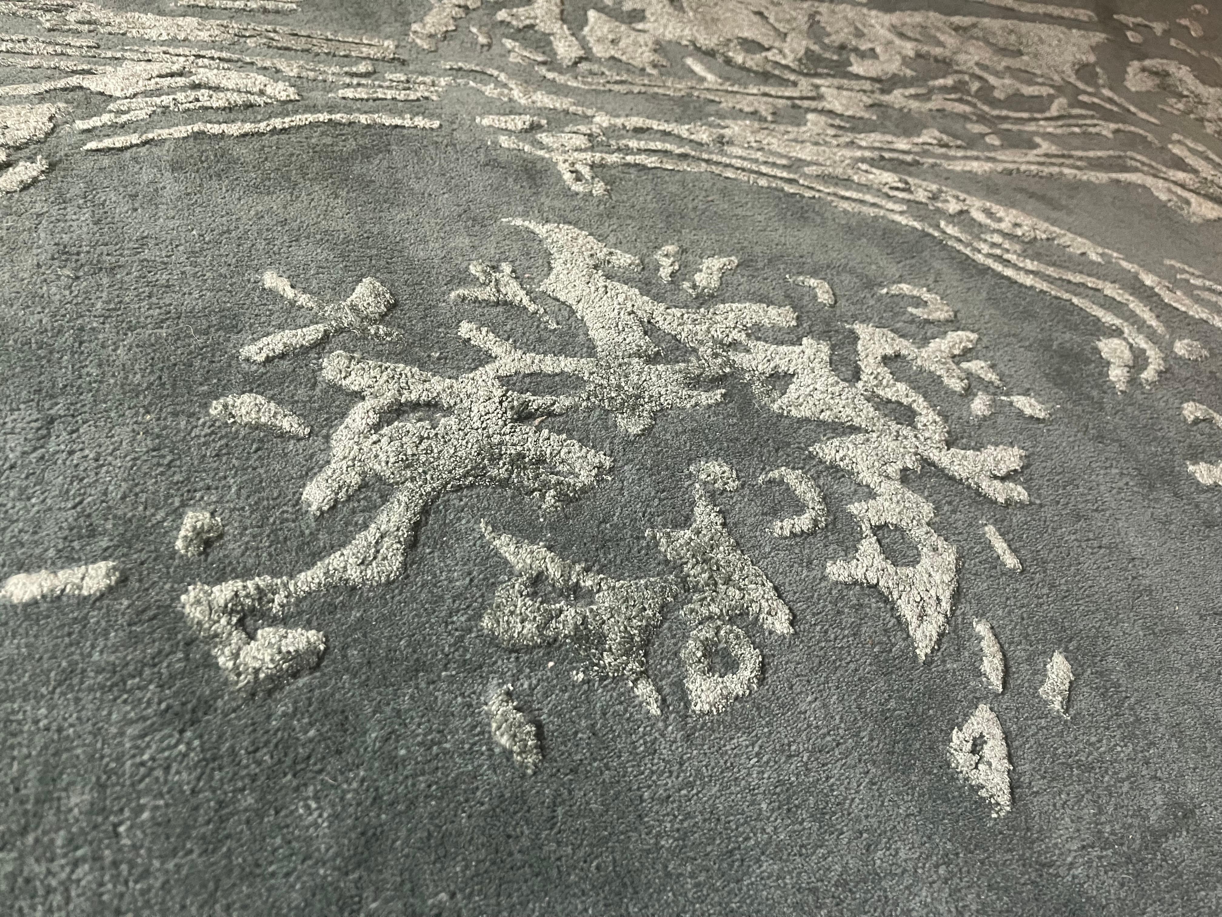 Dieser Teppich ist handgetuftet in Premium Qualität. Die besten Materialen, wie hochwertige Neuseelandwolle und Tencel werden verarbeitet. Eine integrierte rutschfeste Unterlage sorgt für super Laufgefühl und wirkt extrem schalldämmend. Dieses