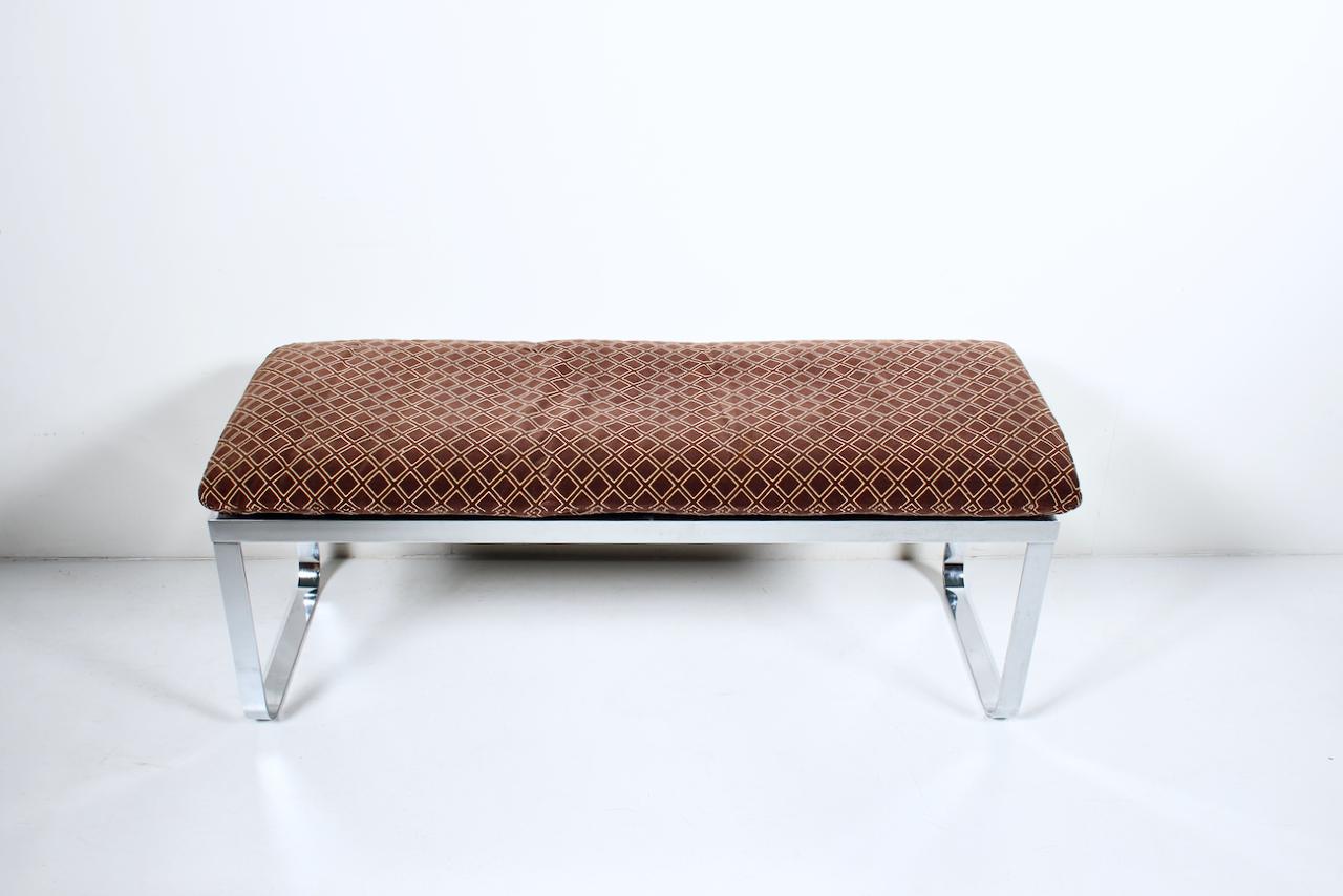 Design Institute of America International style cushioned Chrome Bench. Fabrice présente une forme rectangulaire chromée nette et réfléchissante, avec une base équilibrée et incurvée, et un tissu coussiné en velours cacao et beige, conçu à partir de