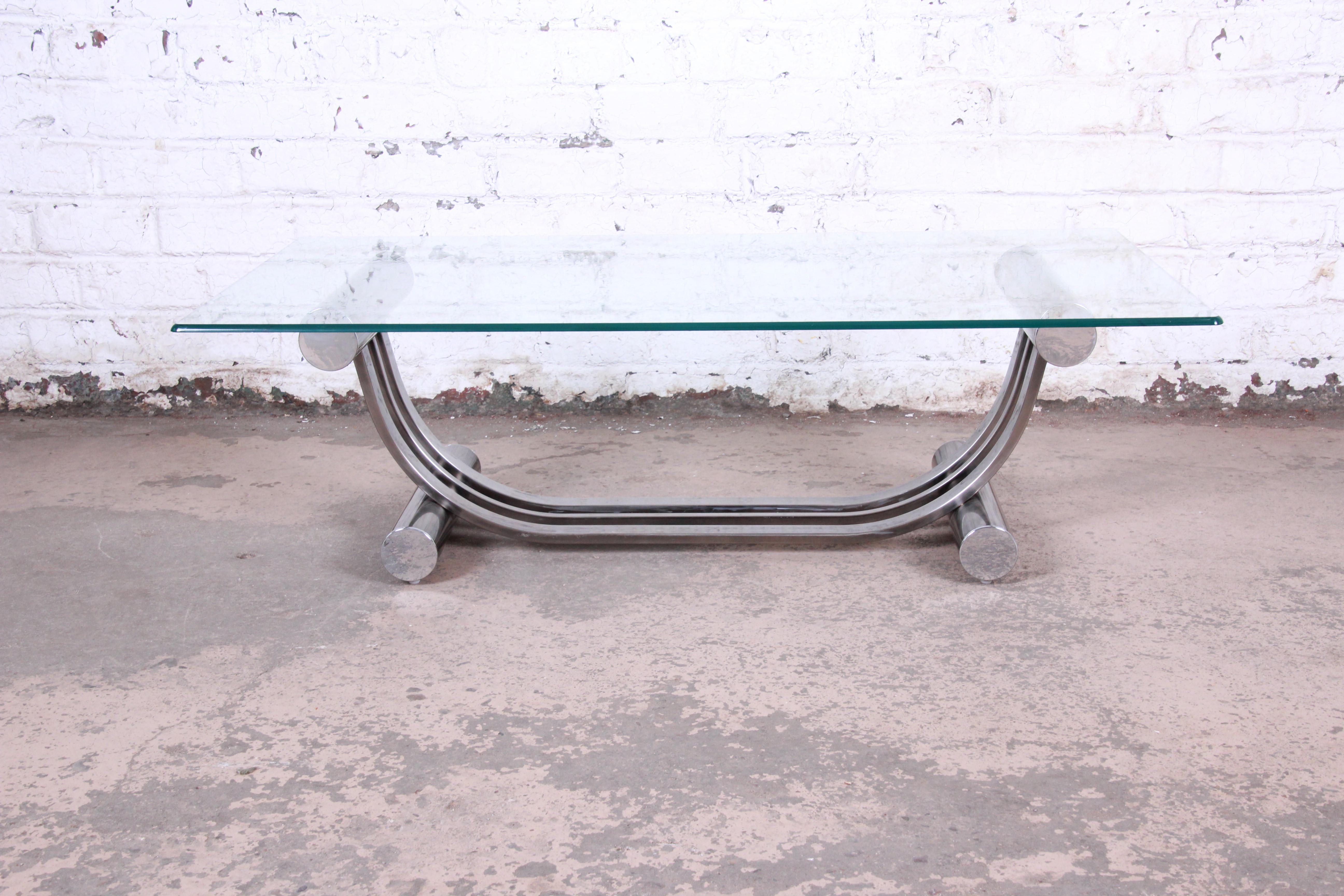 A unique Art Deco style chrome and glass coffee table by Design Institute America. The table features a harp-shaped chrome base and thick glass top. The original DIA label is present. The table is in very good original vintage condition.