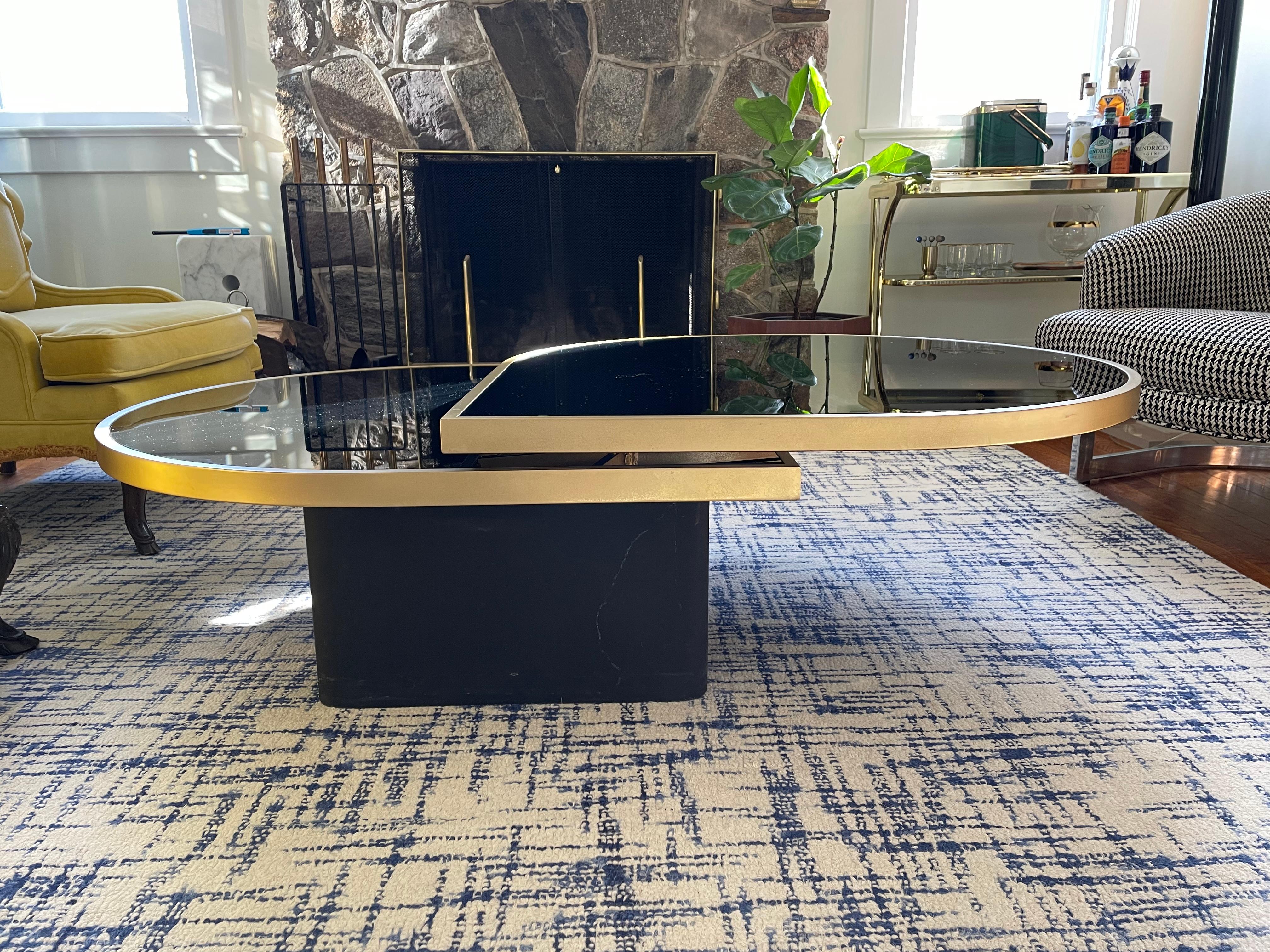 Begehrter, drehbarer Cocktailtisch aus schwarzem Glas und Messing von DIA. Einzigartig ist, dass die Messingverzierung eine matte Oberfläche über der glänzenden hat. 

Unterzeichnet (Design Institute American, Inc. 1983, DIA 48447). Milo Baughman