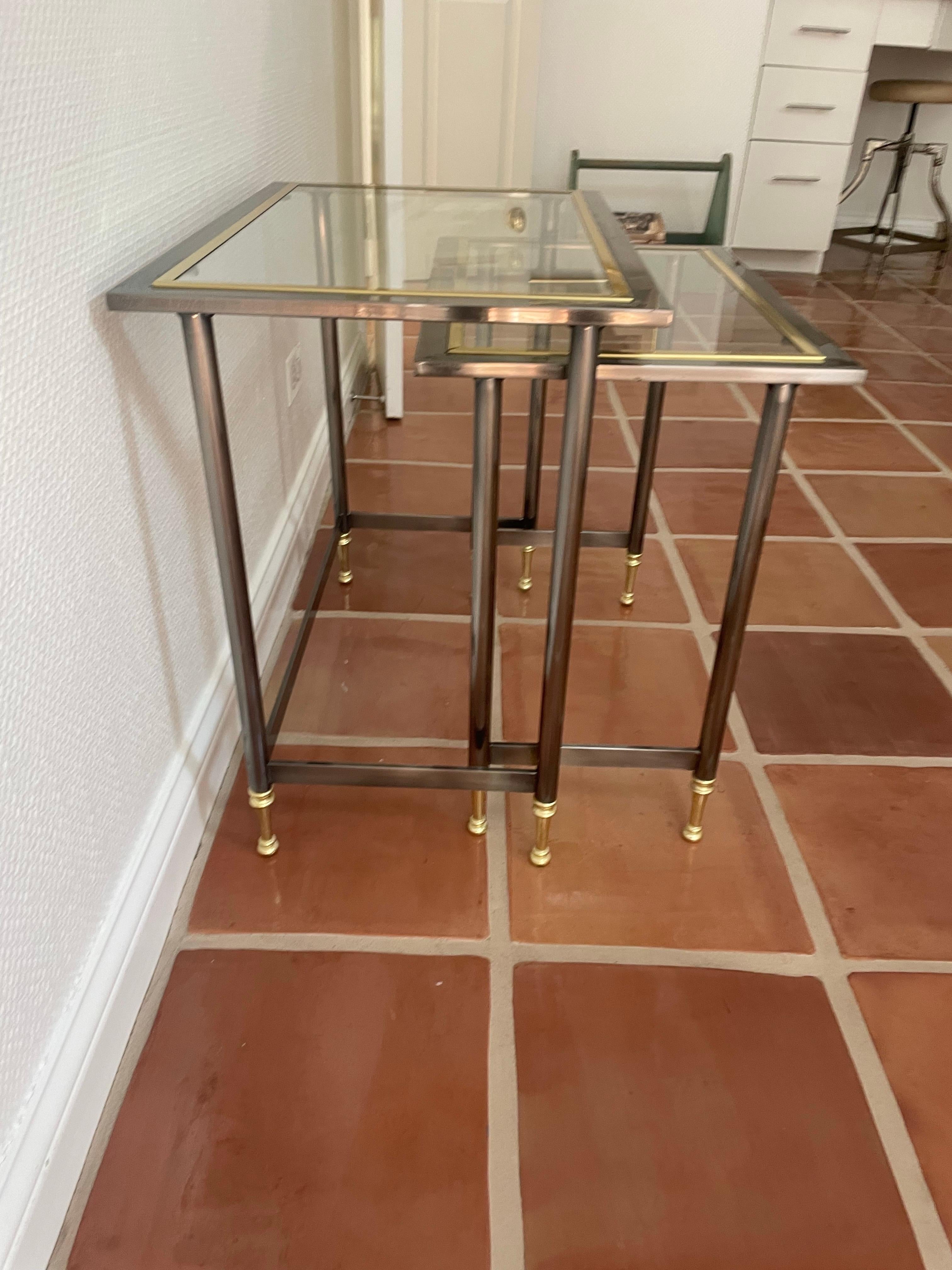 Si tratta di un set di tavolini in ottone, cromo spazzolato e vetro in splendide condizioni vintage realizzato da Design Institute America. 