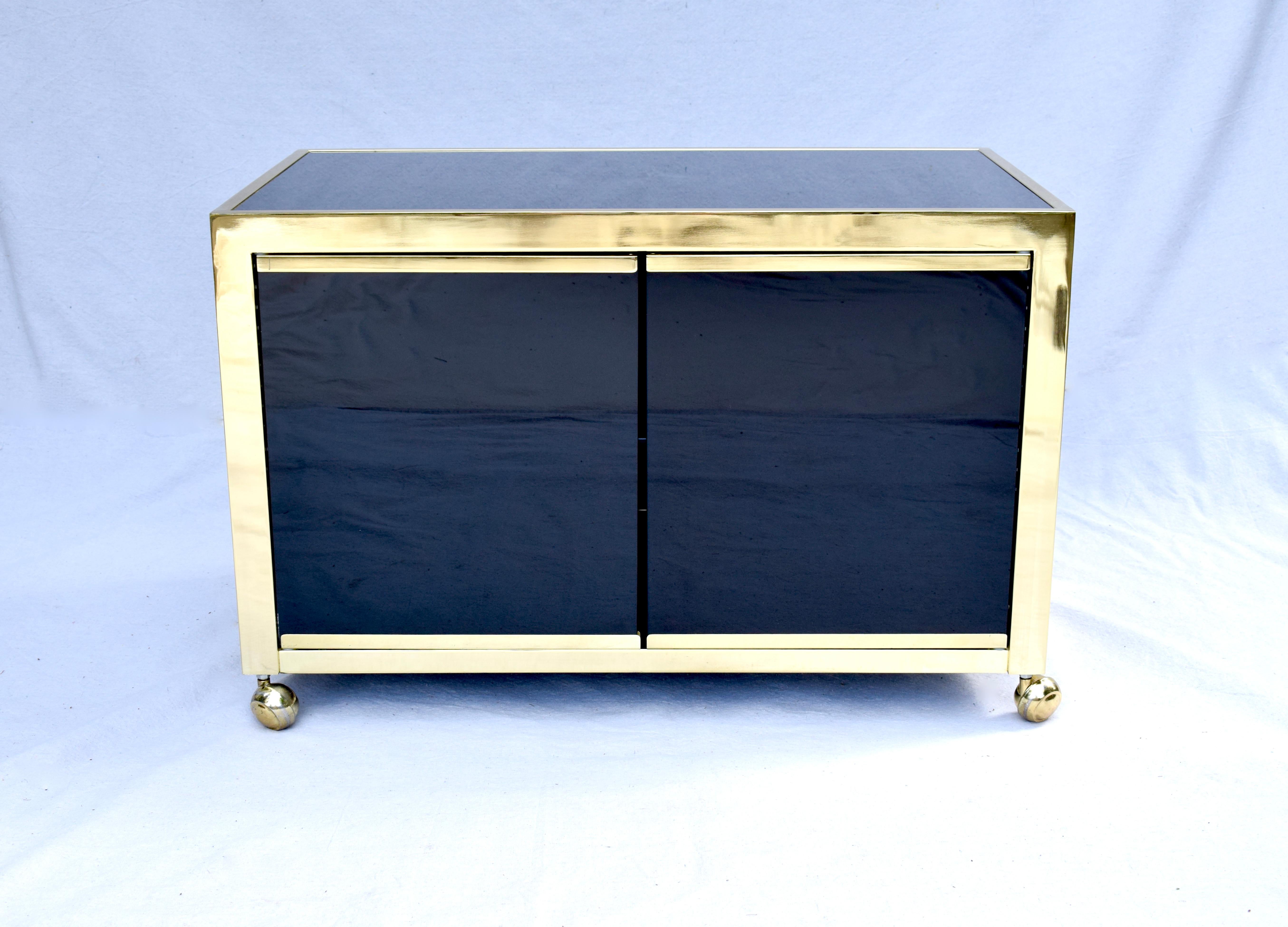 Postmodern Milo Baughman for Design Institute of America black Glass & Brass Cabinet on brass casters. Top, center & base glass shelf & surfaces can be disassembled & wrapped for safe transport. Marvelous multifunctional cabinetry scarcely seen.