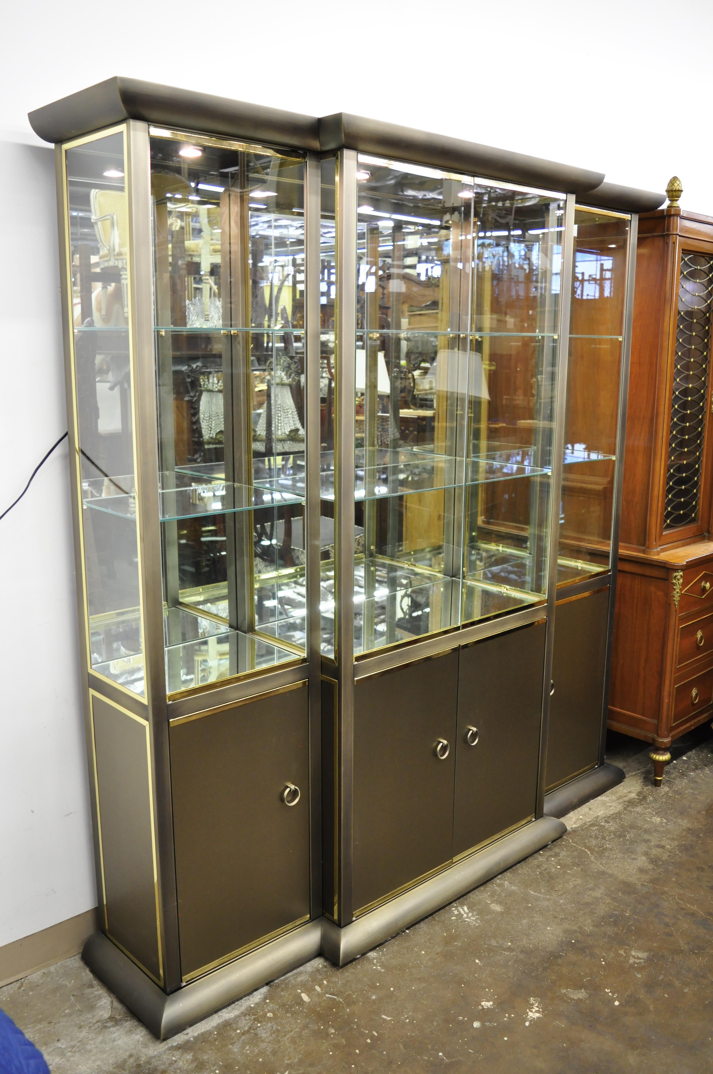 Mid-Century Modern Design Institute of America brass and bronze finish mirror display cabinet curio. Item features brushed bronze finish, brass trim, 6 shelves top, 3 bottom, mirror back and lower section, 5 part construction (top, bottom, 3