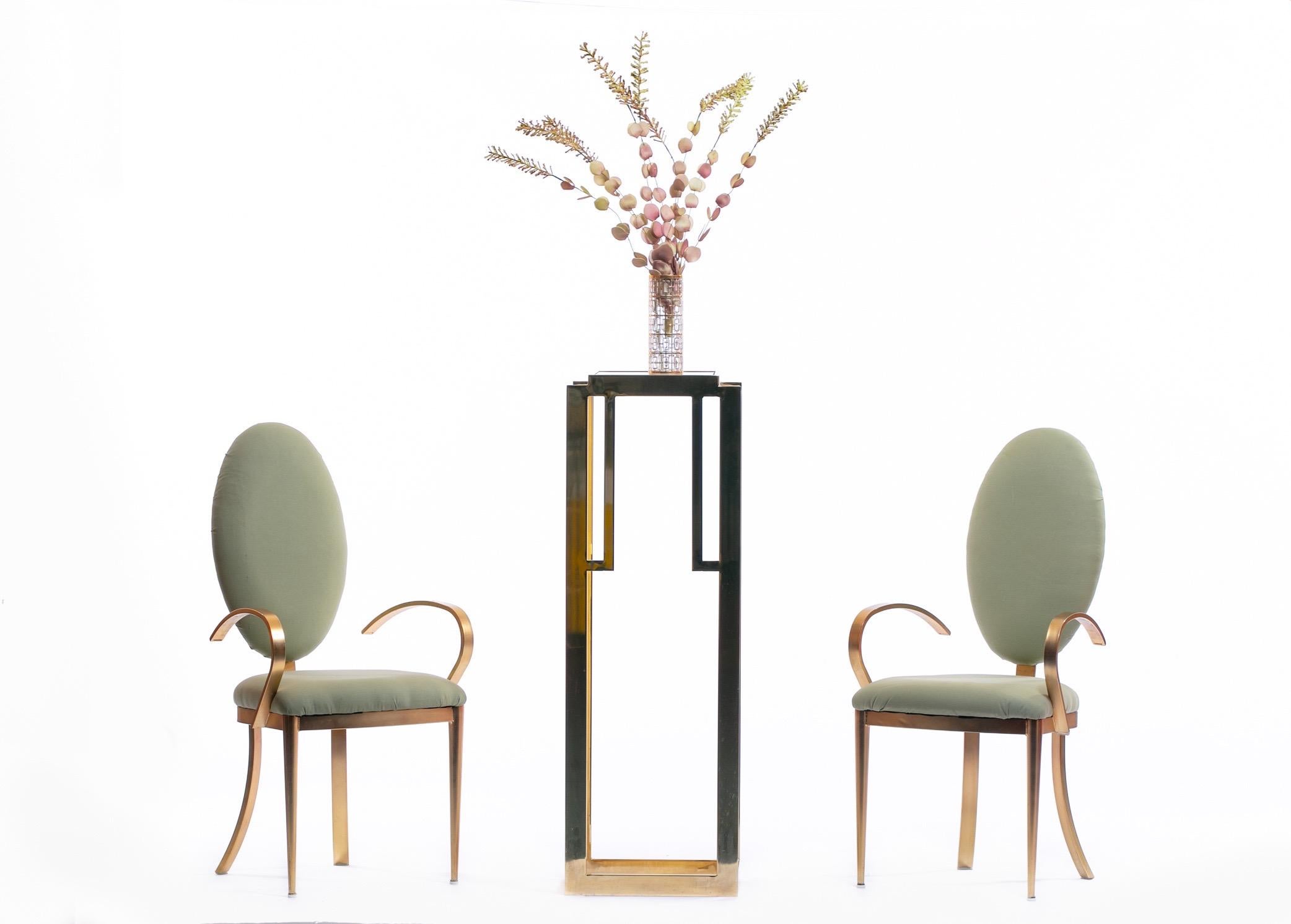 Beautiful pair of tall brushed brass tall oval back chairs by Design Institute of America. Well made and sturdy brass frame softened by soft curves and an oval back. Brass is in vintage condition but may be professionally polished for an upcharge.