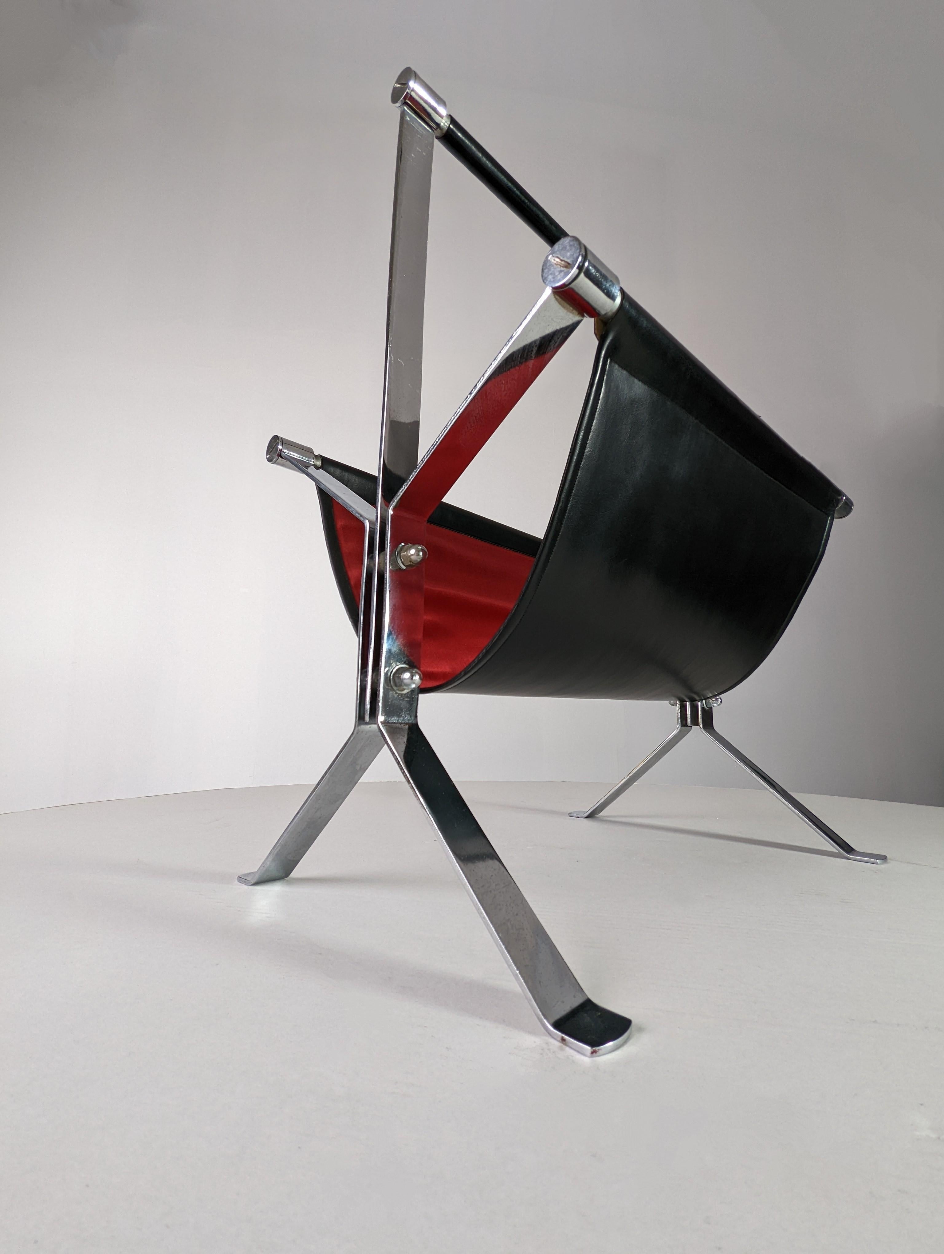 Fantastic magazine rack attributed to the great Venetian designer Alessandro Albrizzi, perfectly combining elegant black leather with red interior and chrome structure that shows us the elegant lines of Albrizzi's designs, such as its characteristic