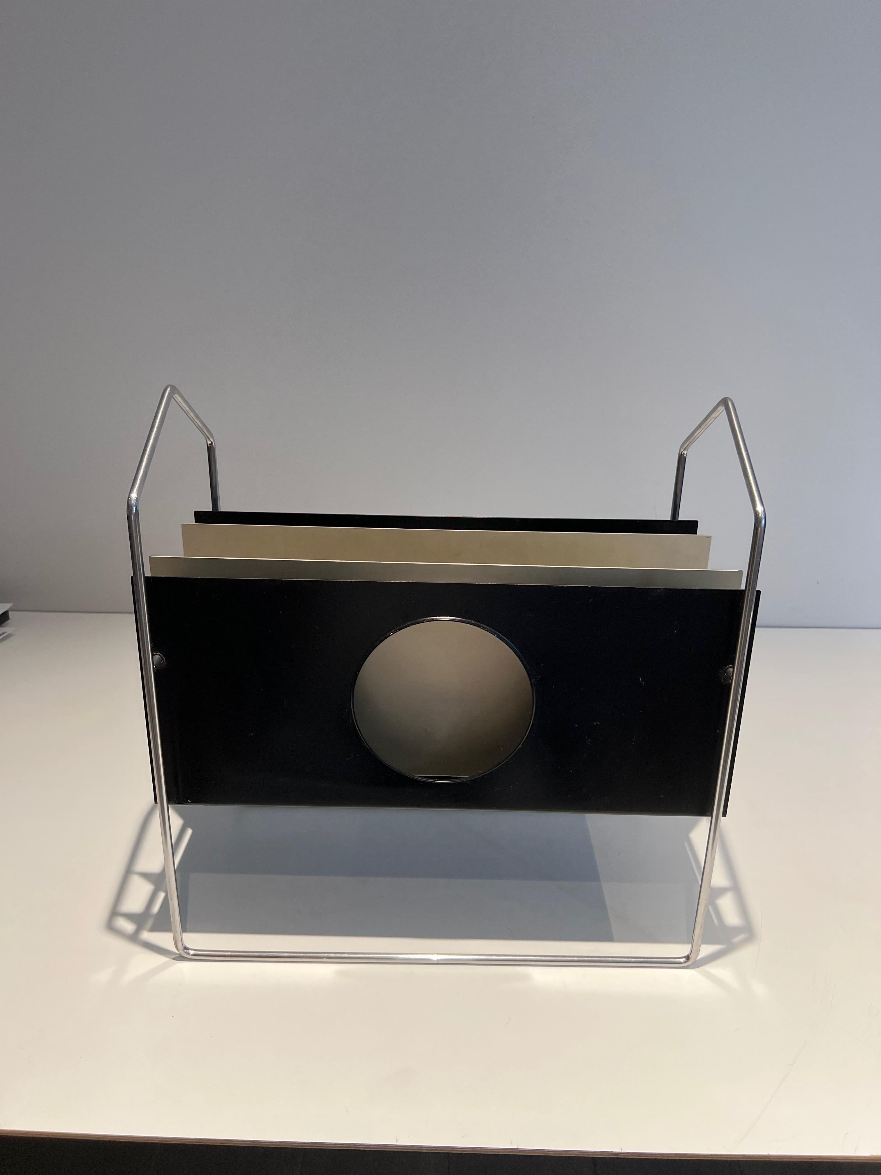 This design magazine rack is made of chrome and black and white lacquered metal. The magazine compartments are sliding. This is a French work. Circa 1950