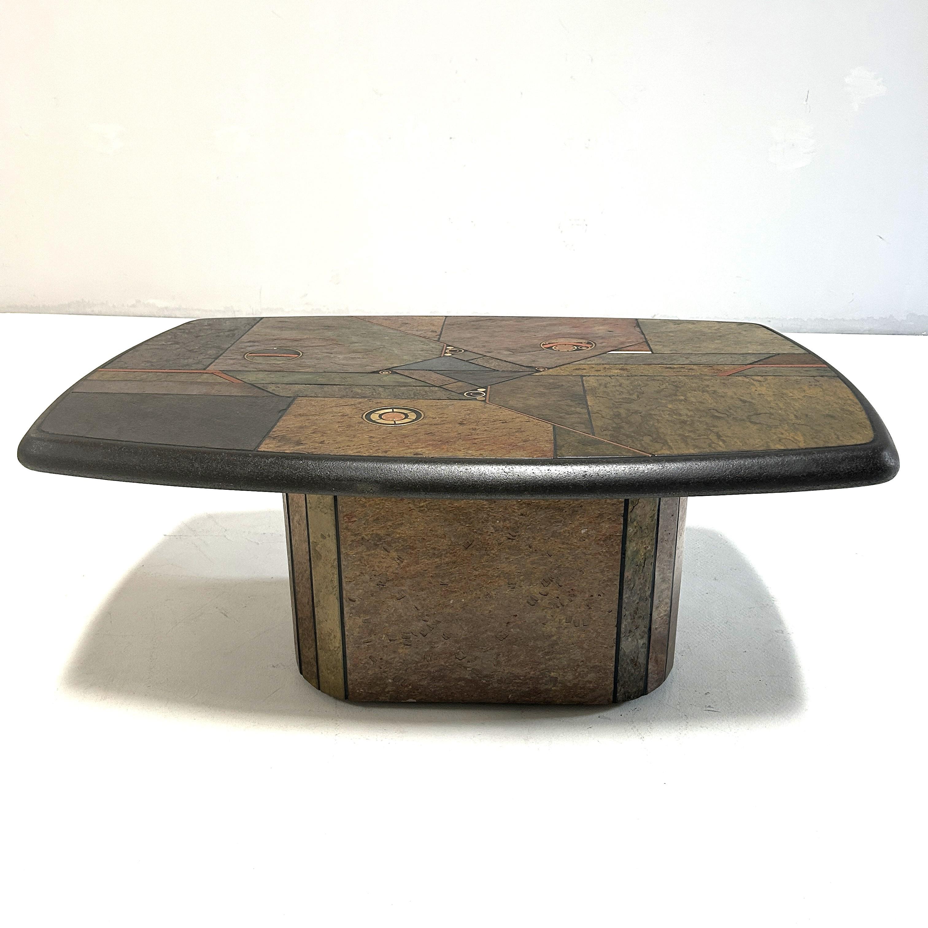 Unique coffe table by Design P

The tabletop and base are made of Indian slate, various copper and brass elements and a British coin.
The base of the table can be dismantled.

The tabletop shows the signature of Design P.