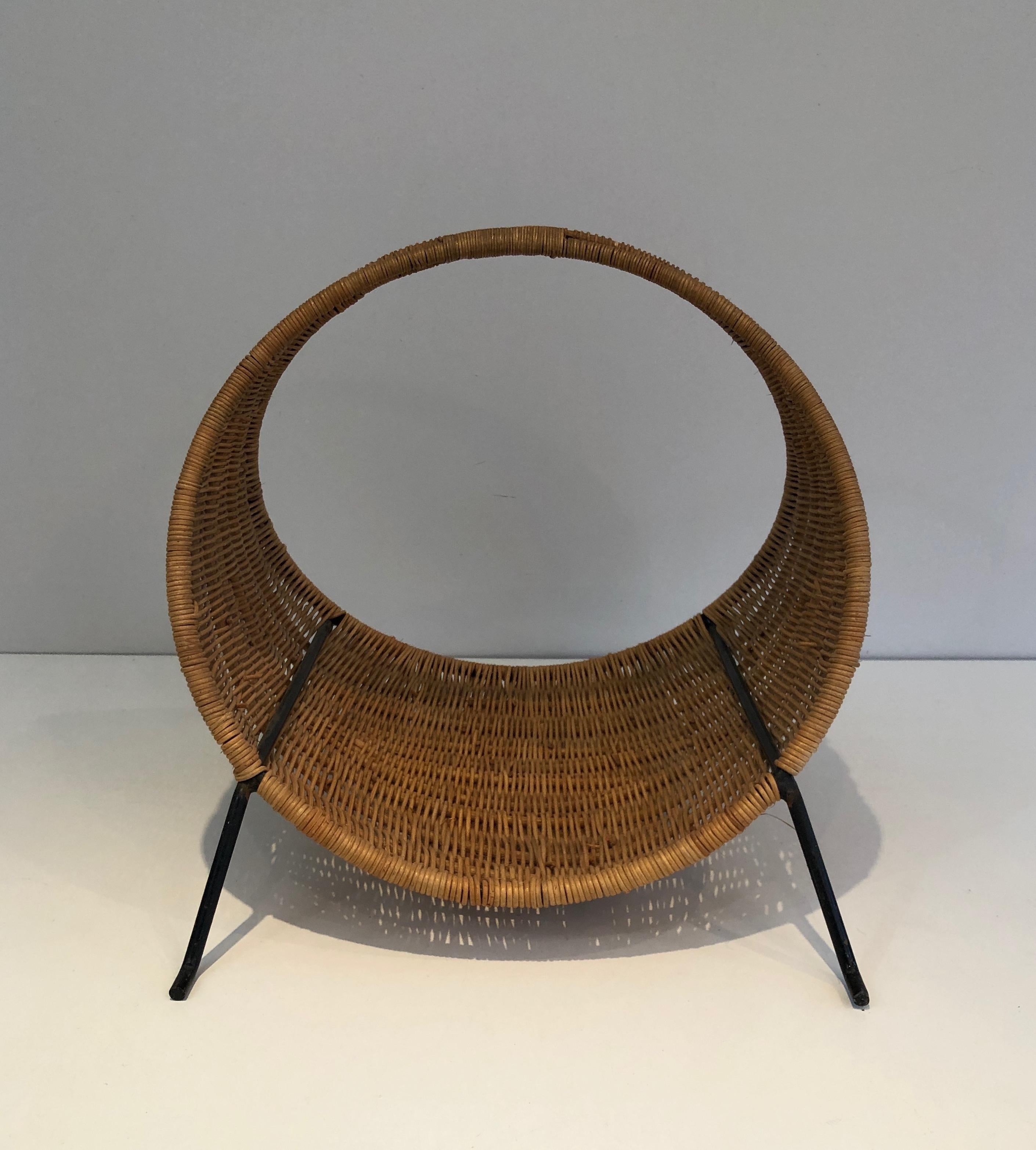 This very nice and unusual design logs holder is made of rattan and black lacquered metal. This is a French work, circa 1970.