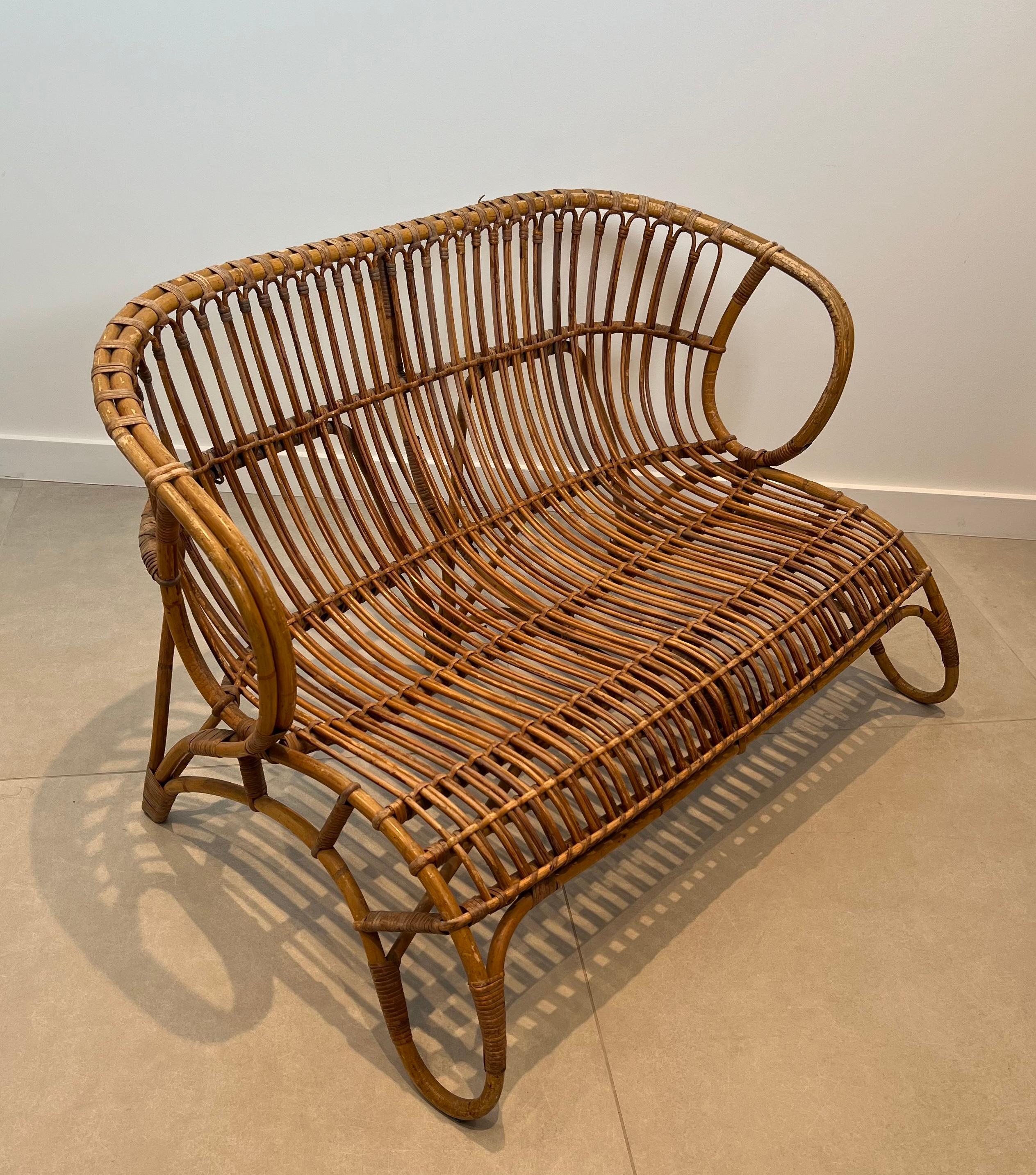 Questa panchina dal design molto bello e insolito è realizzata in rattan. Questa è un'opera francese. Circa 1950