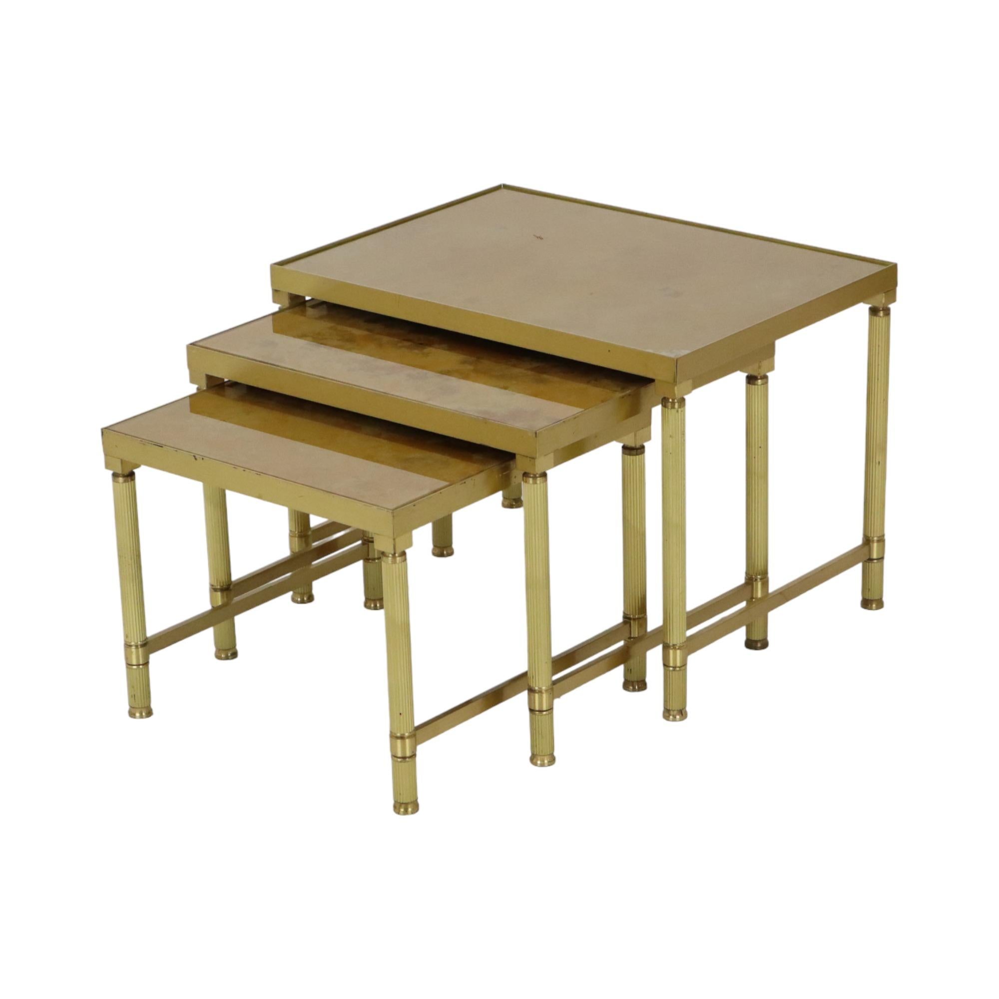 Vintage set of 3 nesting tables in increasing size, yellow copper (brass) base and gold-coloured glass top with marble effect, completely in the style of Maison Jansen, Hollywood Regency, 1960s, France.

Beautiful set of side tables of very high
