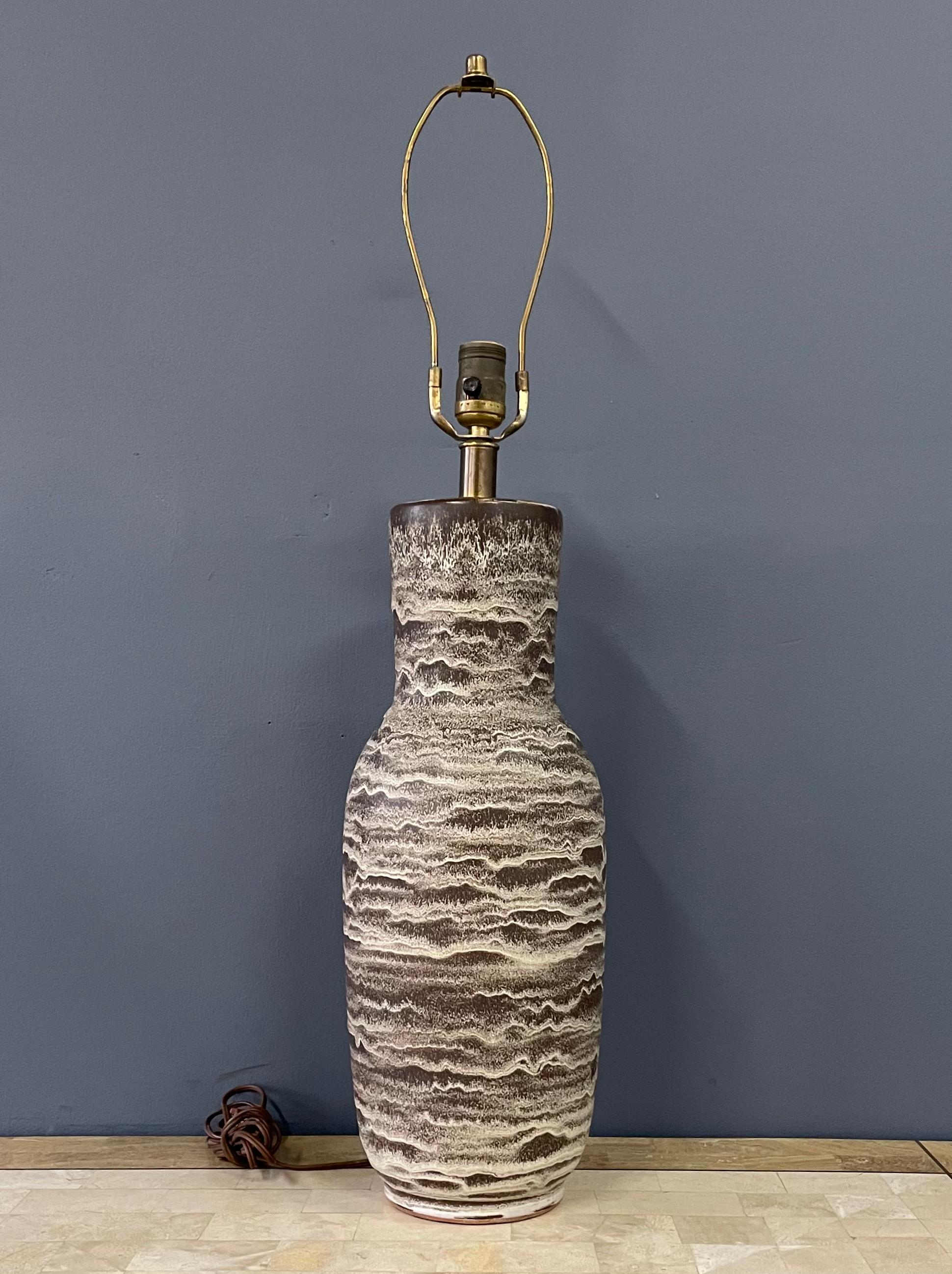 Lampe de table en céramique à double ébrasement, fabriquée à la main par Design Technics, datant du milieu du siècle dernier. Cette colonne évasée présente un motif strié dans des tons naturels de taupe, brun foncé, crème, blanc cassé et sable.