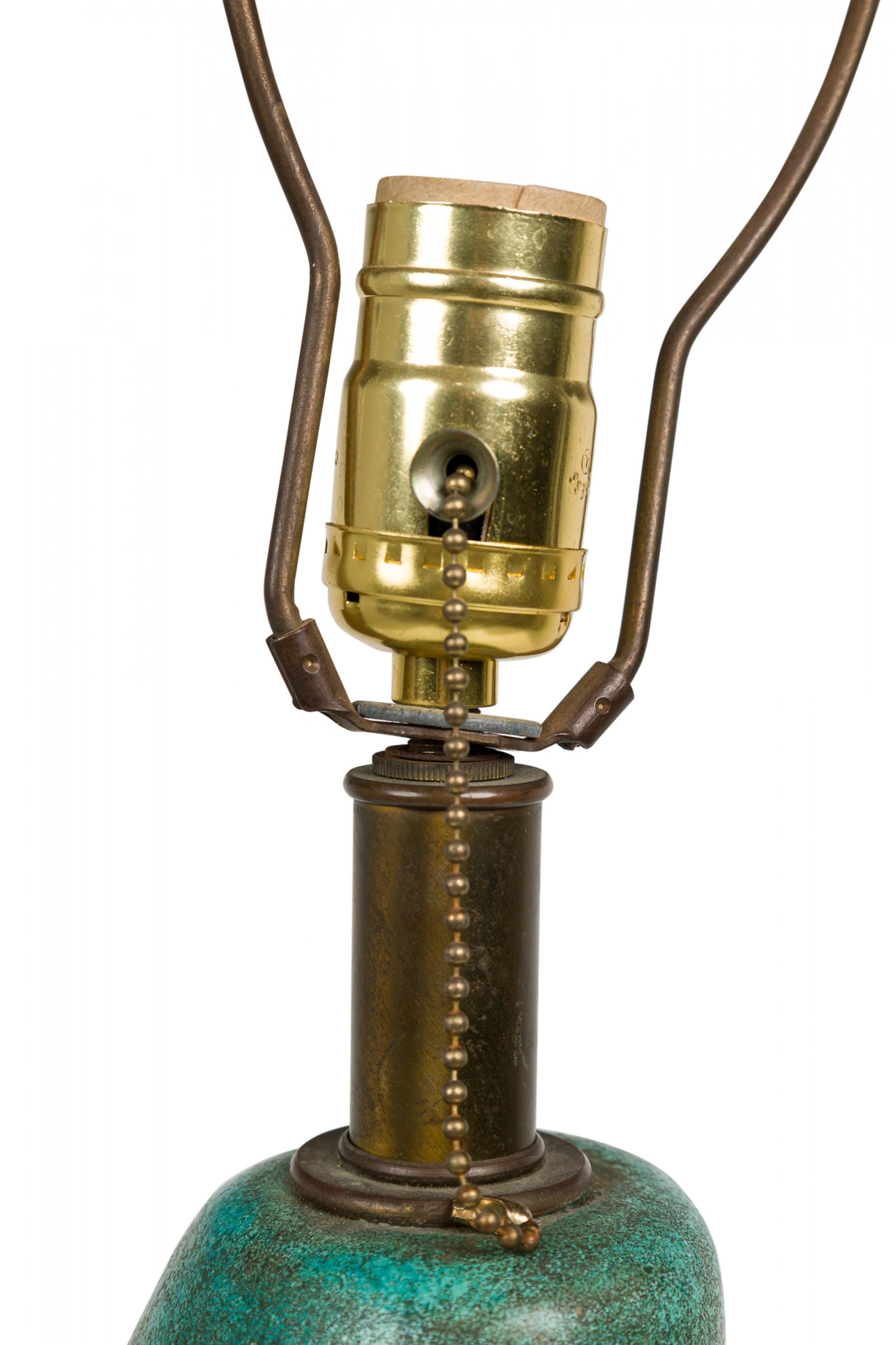 Lampe de table en céramique américaine du milieu du siècle, de forme organique effilée, dotée d'une tige en laiton allongée, d'une harpe, d'un épi de faîtage cylindrique et d'une prise d'interrupteur fonctionnelle, d'un corps subtilement nervuré