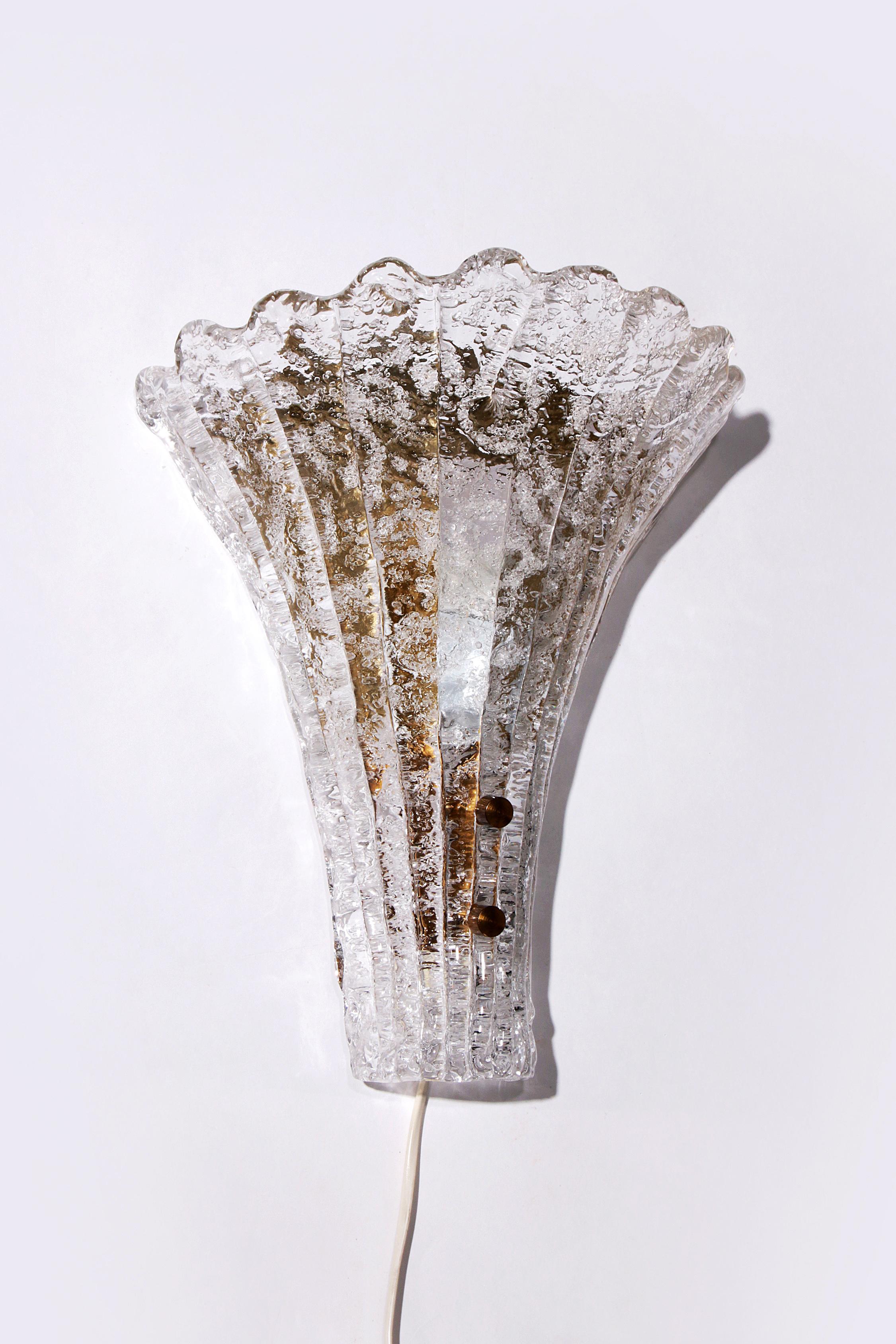 Découvrez l'aspect élégant de l'applique Carl Fagerlund, fabriquée par Orrefors. Ce grand modèle, d'une hauteur de 36 cm, allie un charme intemporel à une fonctionnalité moderne. La lampe n'est pas seulement une source d'éclairage mais aussi une