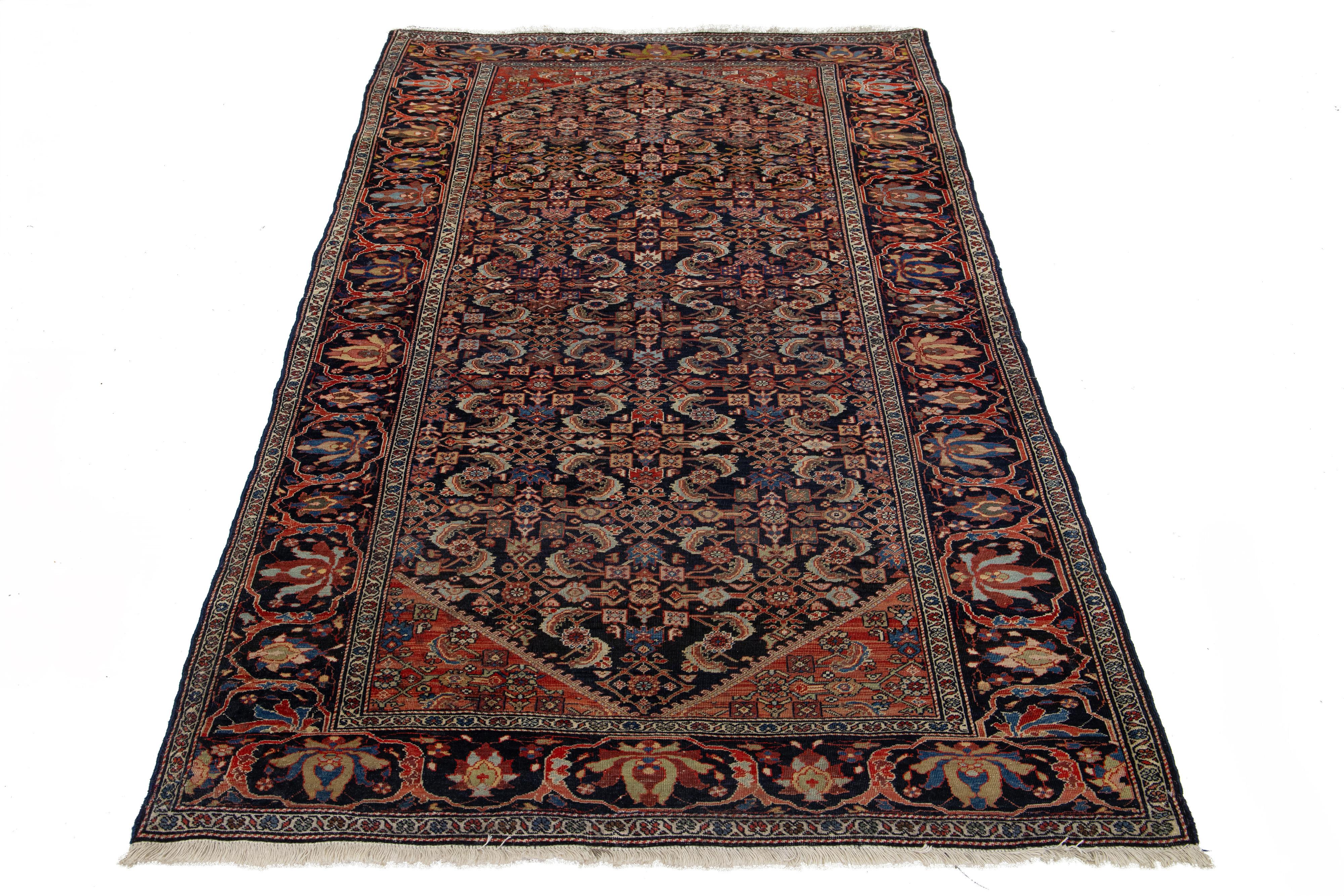 Il s'agit d'un tapis persan Malayer fait à la main et datant du 20e siècle. Il présente un champ bleu foncé avec des accents multicolores sur l'ensemble du motif floral géométrique.

Ce tapis mesure 4'1