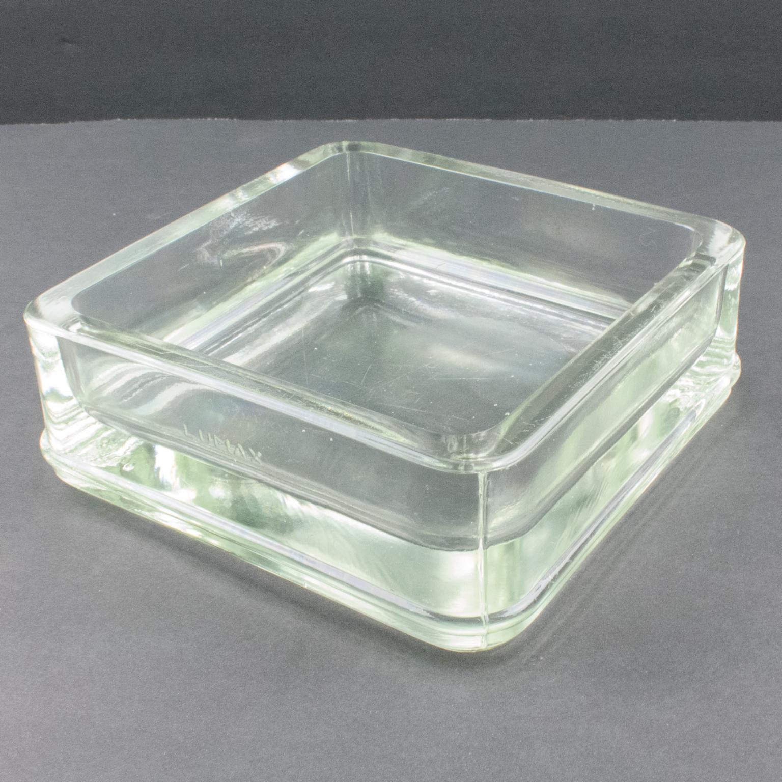 Industrial thick molded glass desktop accessory (desk tidy, cigar ashtray or catchall) manufactured by Lumax, France. Original design by Le Corbusier. Engraved company logo on the side. 
Measurements: 5.94 in. wide (15 cm) x 5.94 in. deep (15 cm) x