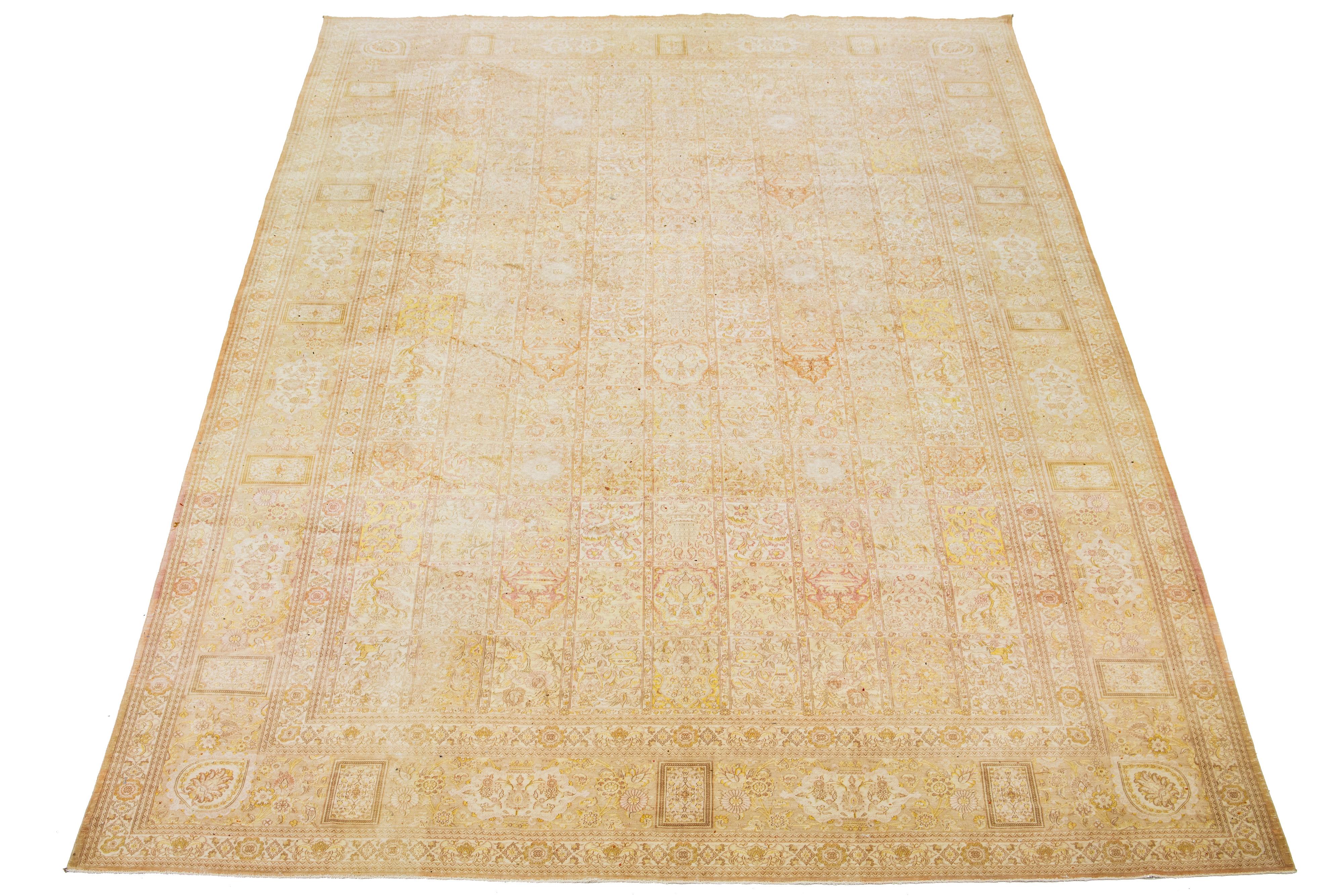 This handcrafted Persian Tabriz wool rug features a traditional floral pattern. The contrast between the beige background highlights the brown, orange, and yellow floral design.

This rug measures 13' x 19'6'.

Our Rugs are professionally cleaned