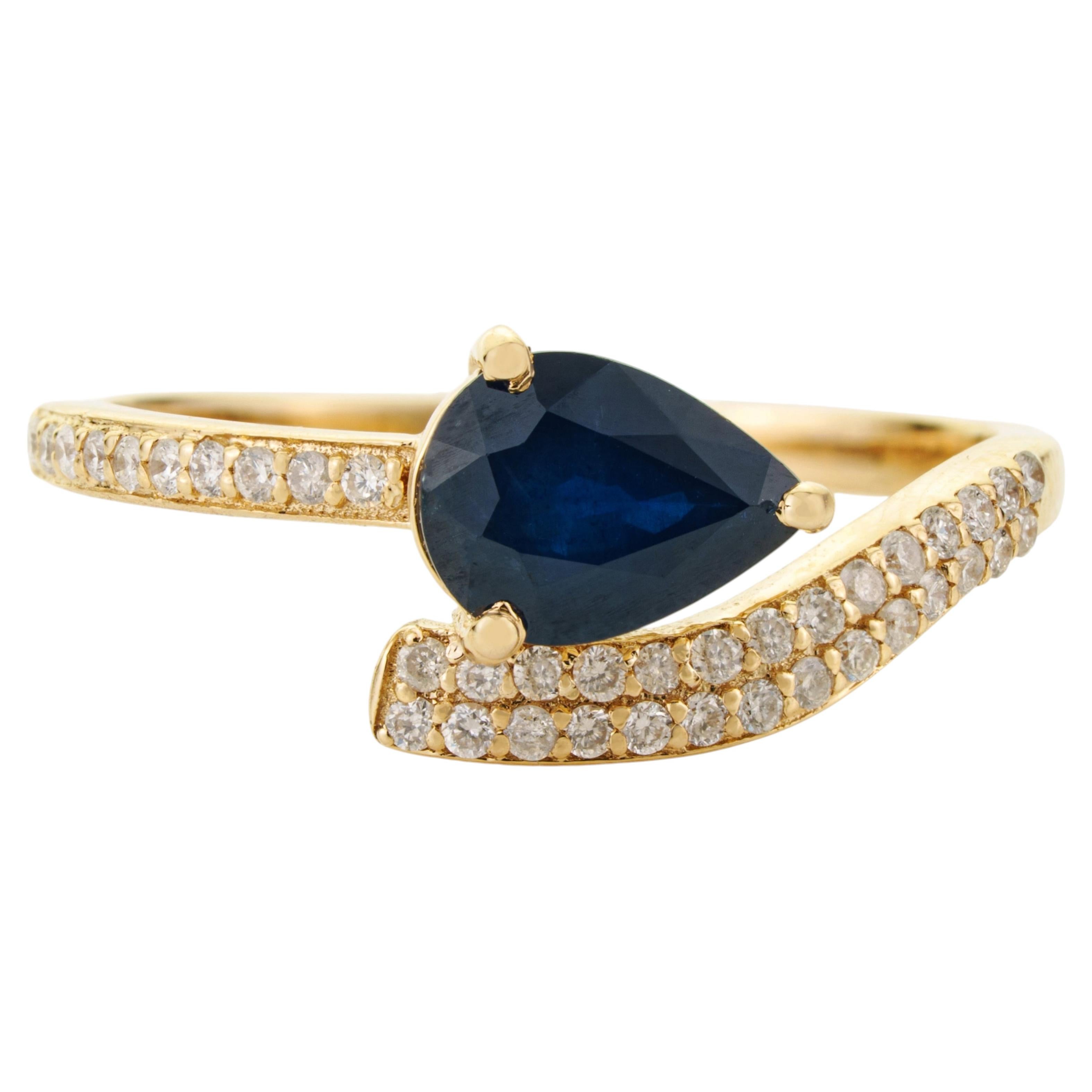 Designer-Ring mit einem blauen Saphir im Birnenschliff (1,12 Karat) und Diamanten im Crossover-Design aus 14 Karat Gelbgold