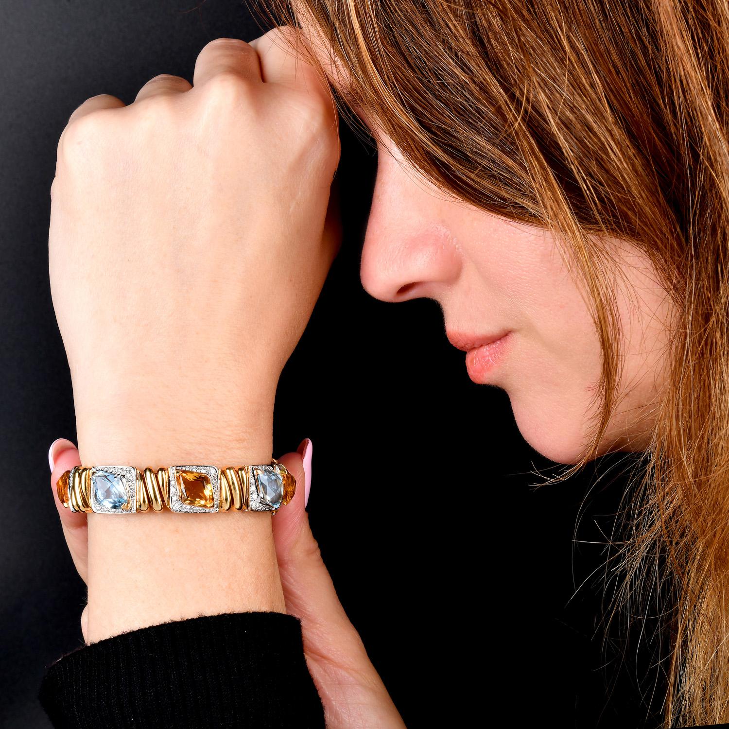 Ce bracelet de créateur exquis est une vitrine rayonnante de savoir-faire et de couleurs. Réalisé avec soin en or jaune et en or blanc 18 carats, il présente une combinaison frappante de pierres précieuses citrine et topaze de taille fantaisie,