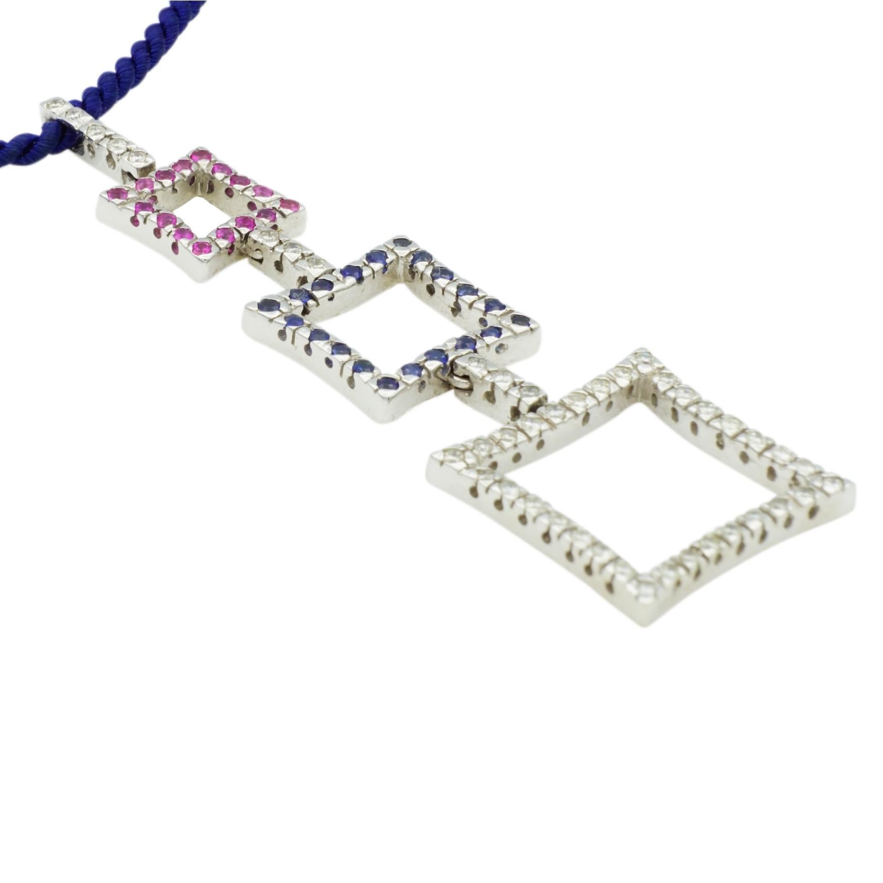 NEW, Contemporary 18kt white gold diamond, vibrant pink sapphire, and blue sapphire designer pendant on a blue silk rope necklace that has an 18kt white gold lobster clasp. Necklace length: 15 Inches; Pendant height: 50 Millimeters; Pendant width: