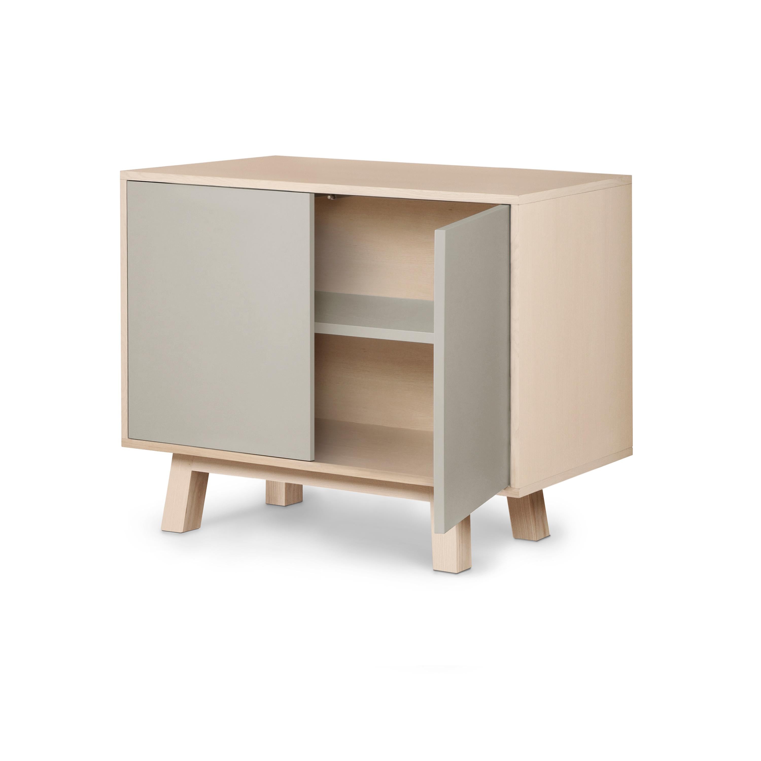 Questo mobile a 2 ante è stato progettato da Eric Gizard, Parigi, e realizzato al 100% a mano in Francia.

È realizzato in legno massello di frassino francese, impiallacciato adh e ante laccate in pannelli MDF. 

Le due porte si aprono con una