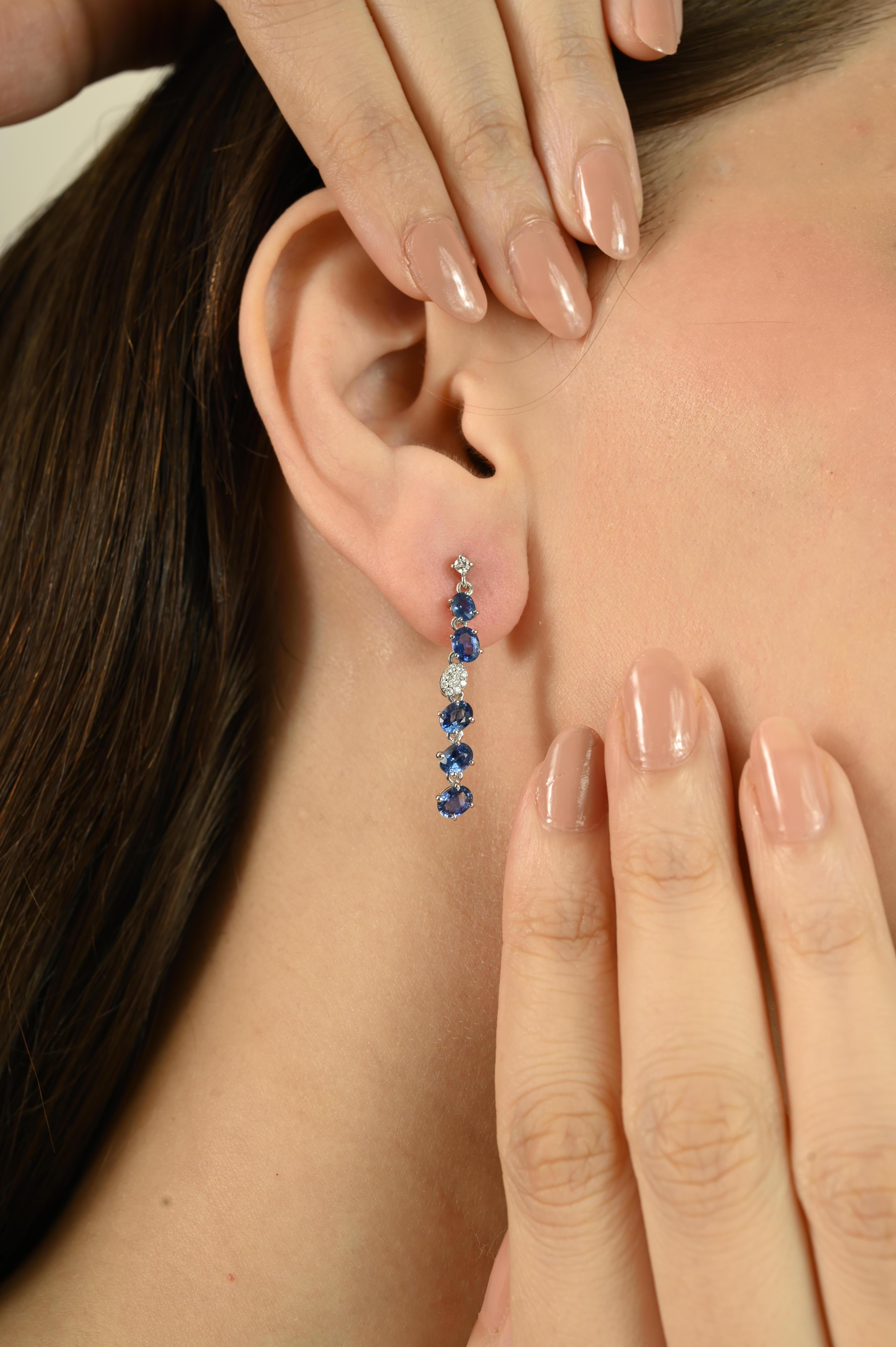 Questi orecchini presentano 3,27 carati di zaffiri blu a taglio ovale abbinati a diamanti tondi taglio brillante da 0,15 carati per un maggiore splendore. Le pietre sono incastonate in oro bianco 14k e creano un elegante design lineare a goccia. Gli