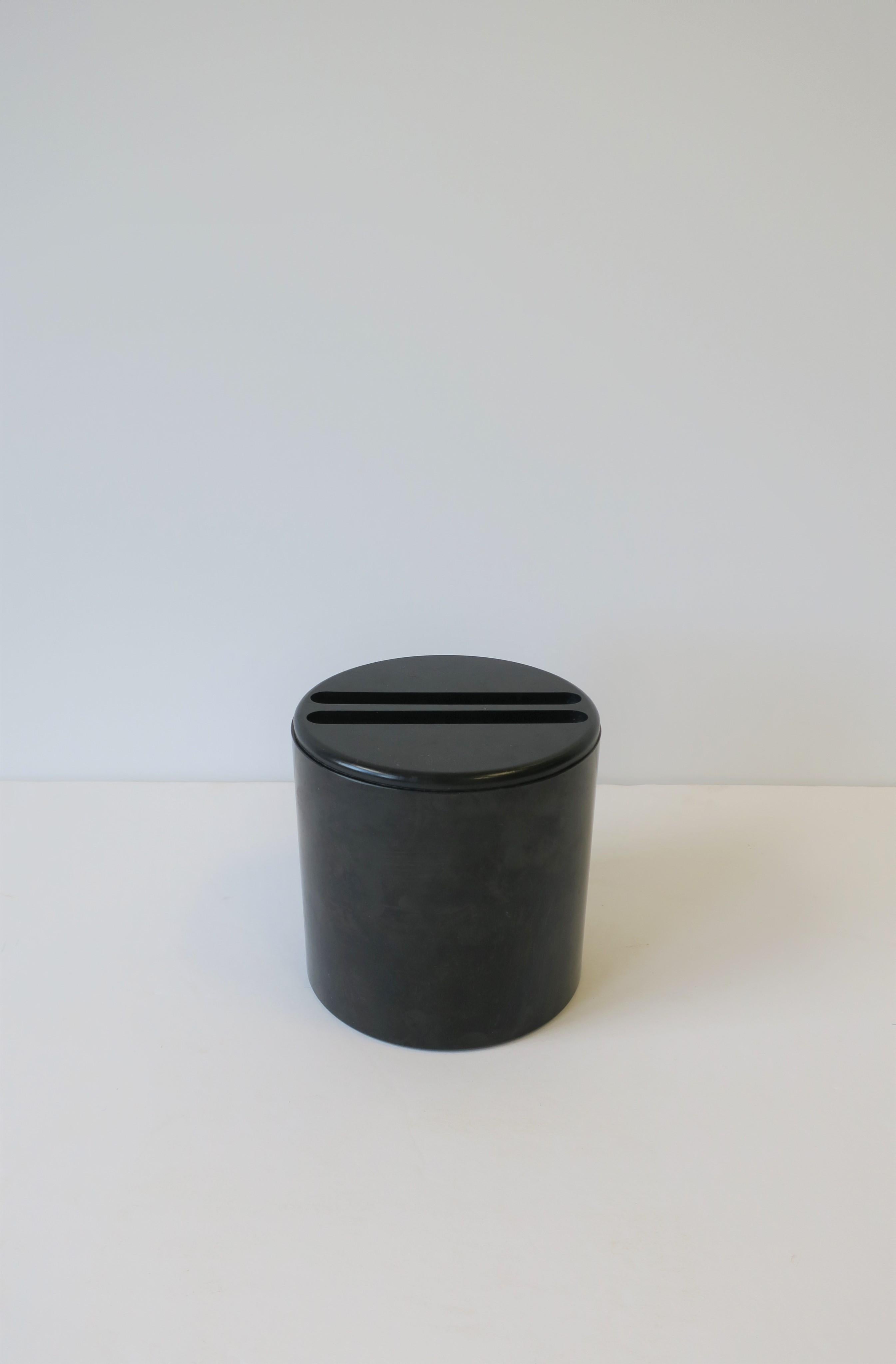 A black Postmodern period Italian round cylindrical vessel box by architect and designer G. F. 'Gianfranco' Frattini for Progetti, circa late-20th century, 1980s-1990s, Italy. A great piece for storage or as a standalone piece. With maker's mark on